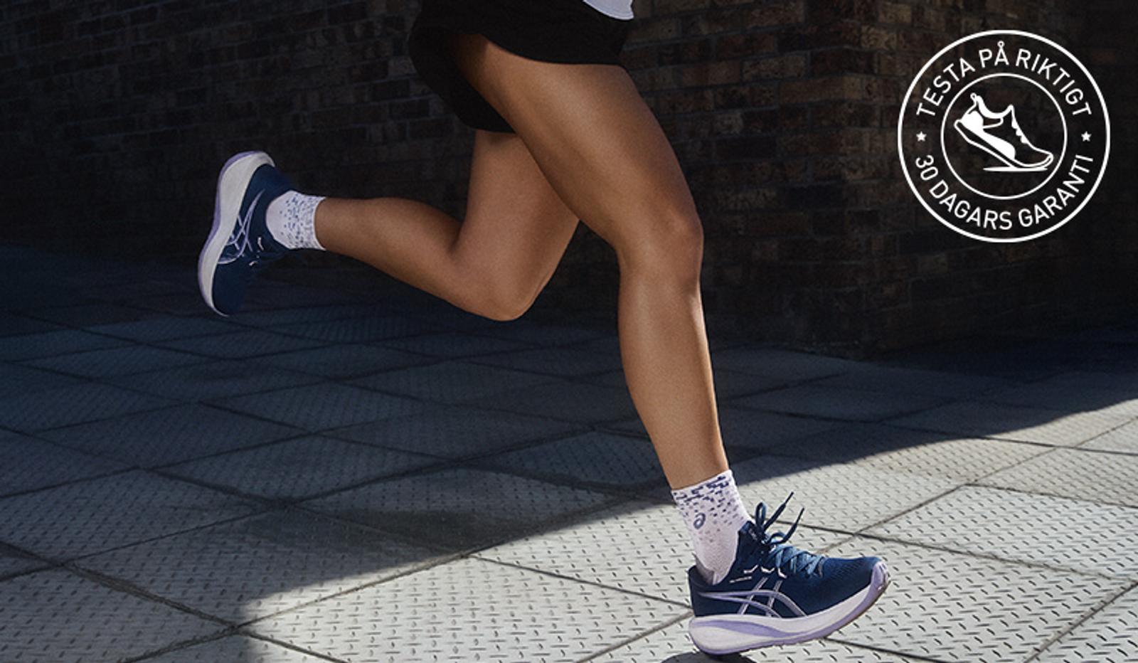 a group of people are running down a road .
