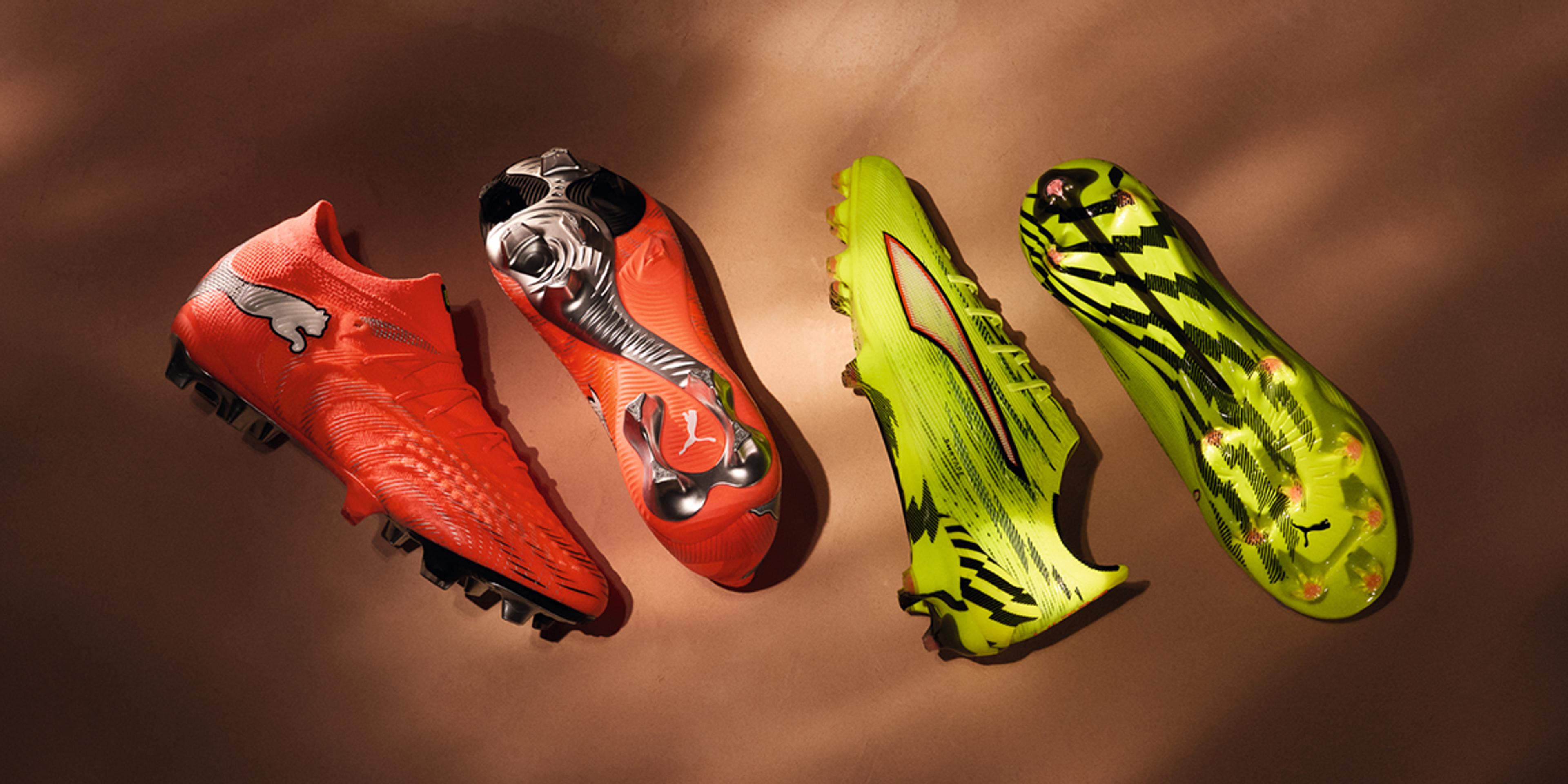 Four bright orange and neon yellow-green Puma soccer cleats on a brown background.