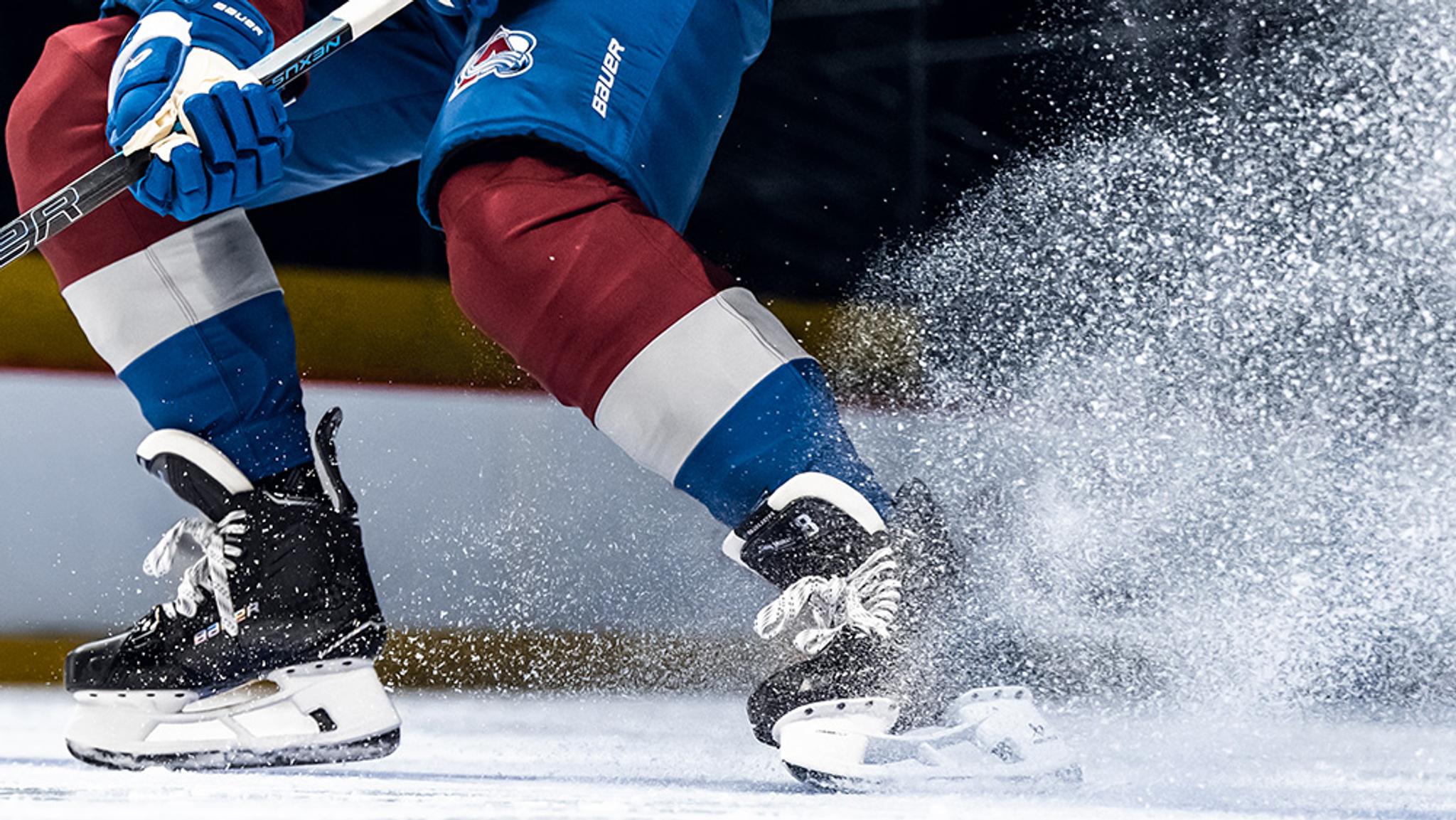 a hockey player is skating on the ice with a stick .