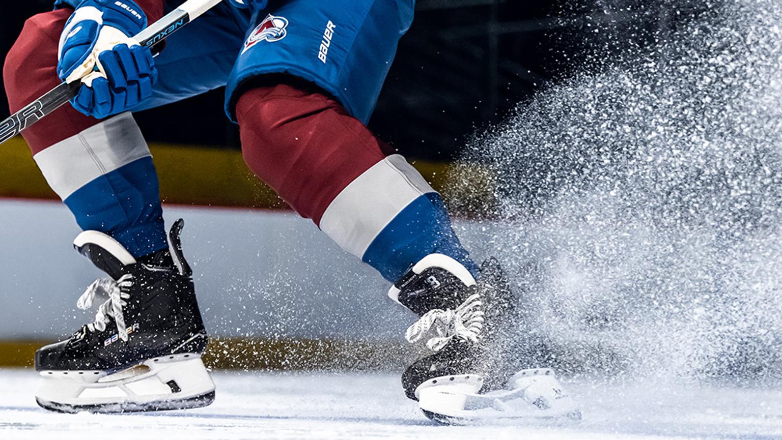 a hockey player is skating on the ice with a stick .