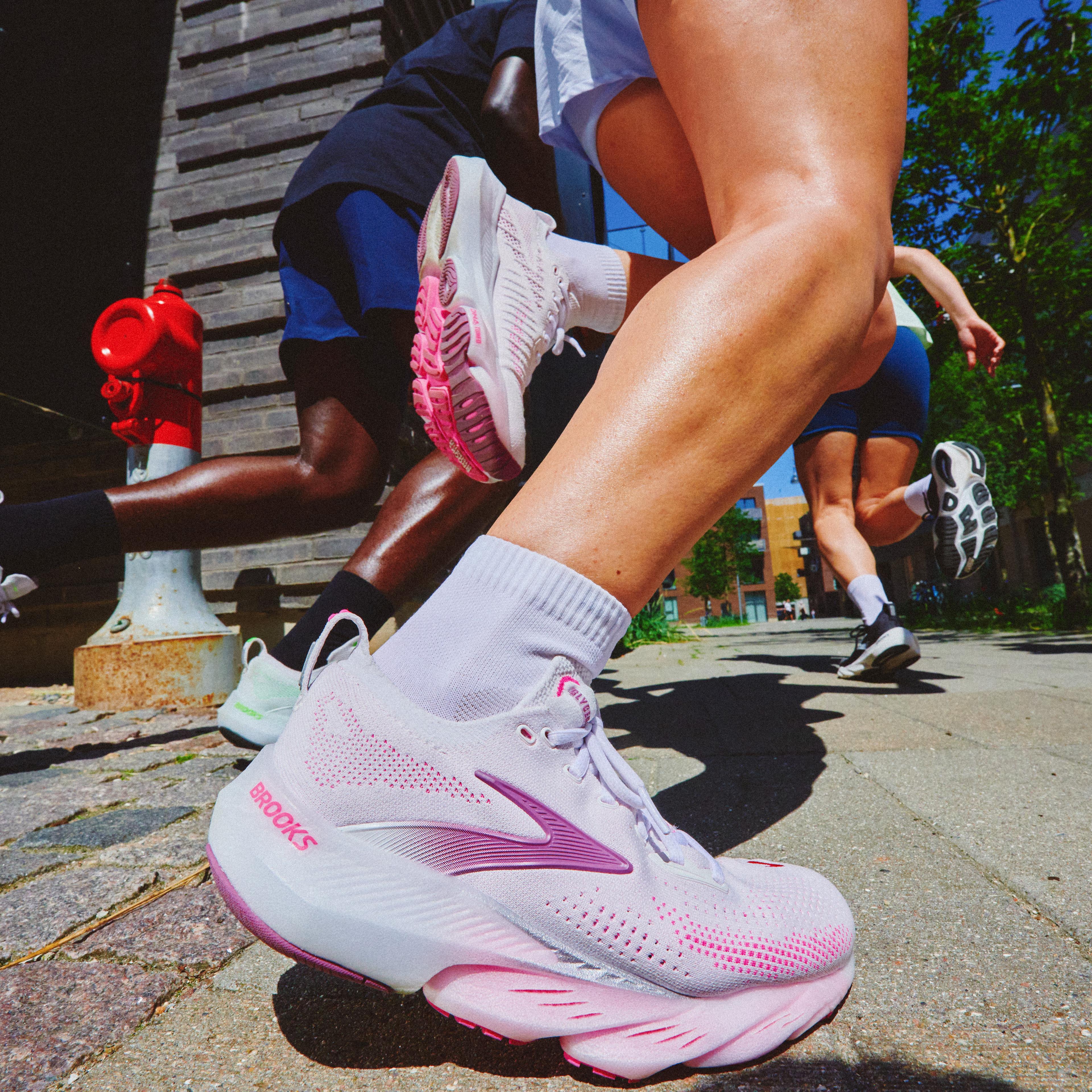 Close-up of runners' legs and colorful running shoes in motion outdoors.