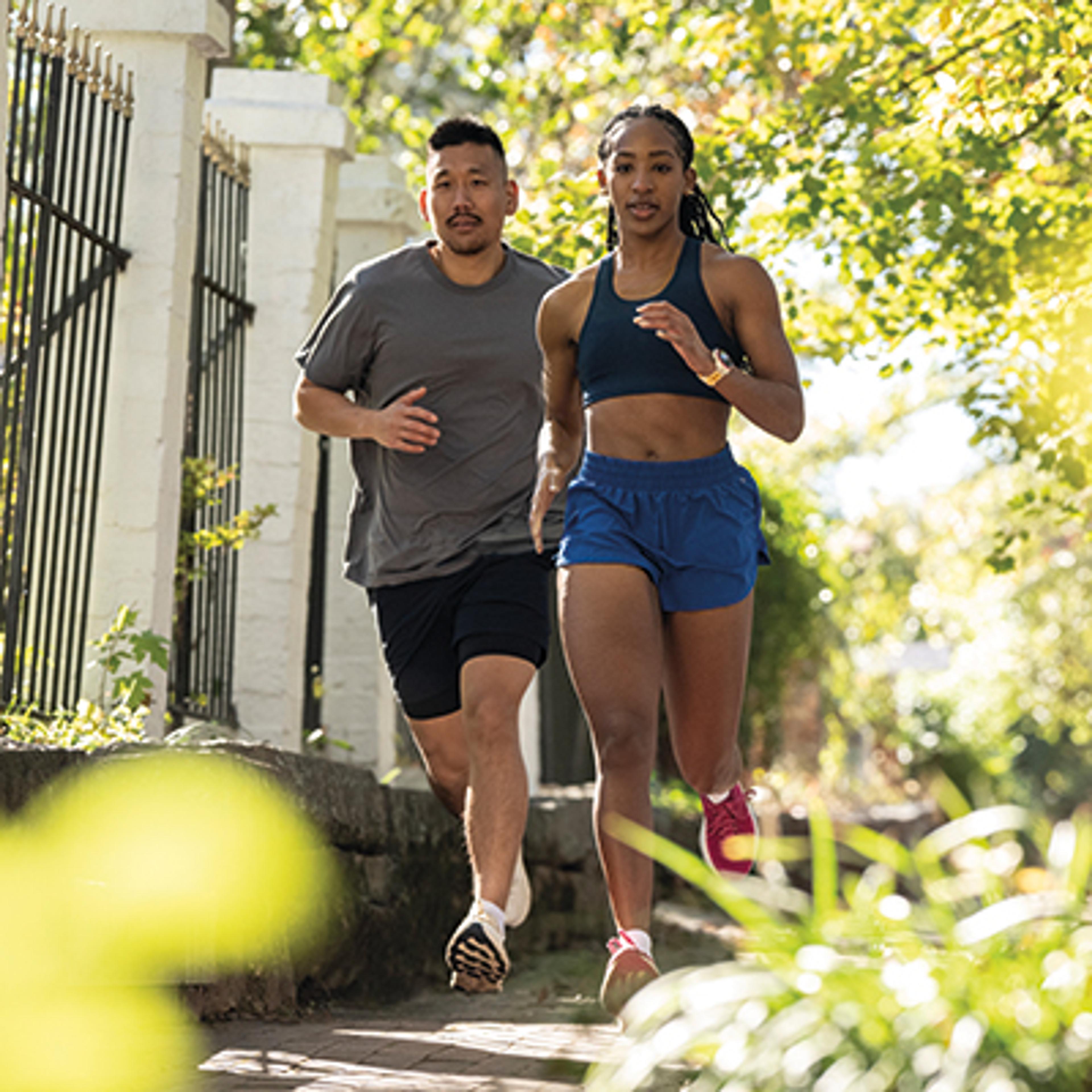 A man and woman running outdoors on a sunny day.