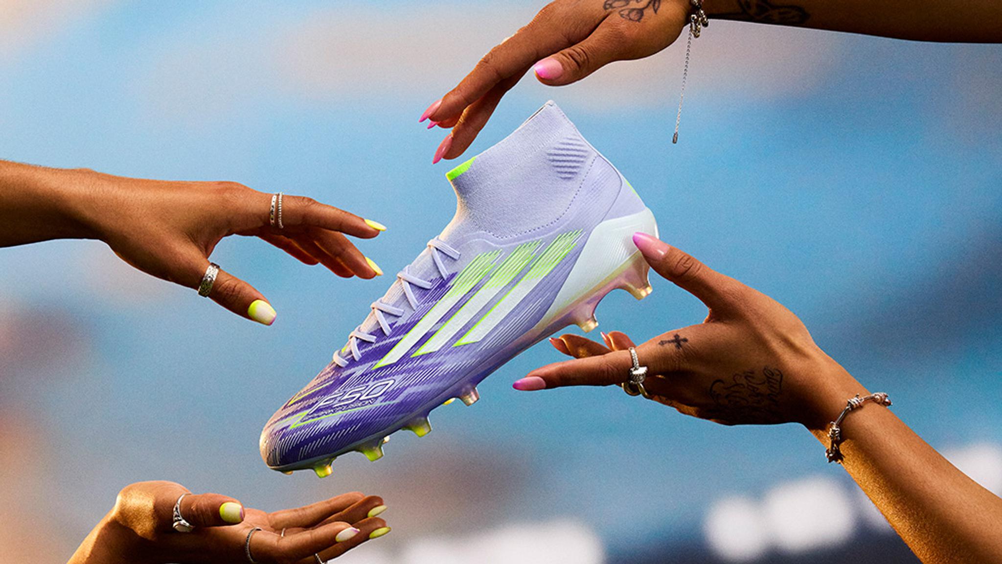a group of people are holding a purple soccer shoe in their hands .
