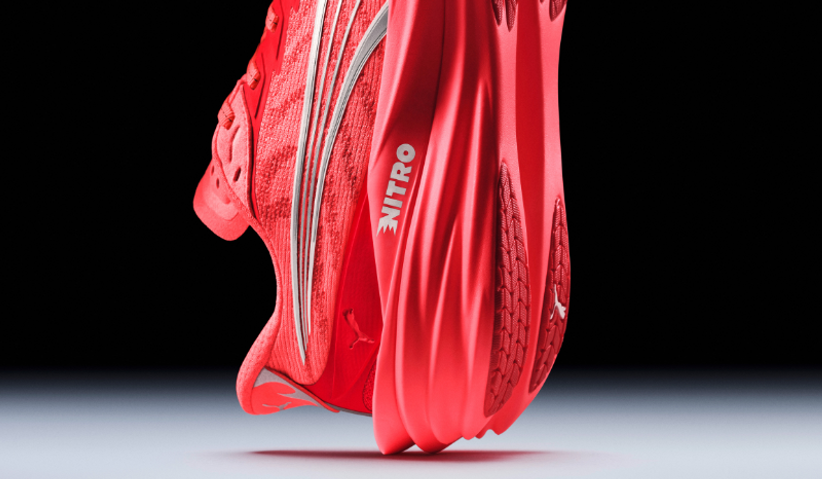 Red Puma Nitro athletic shoe, side view showing the sole.