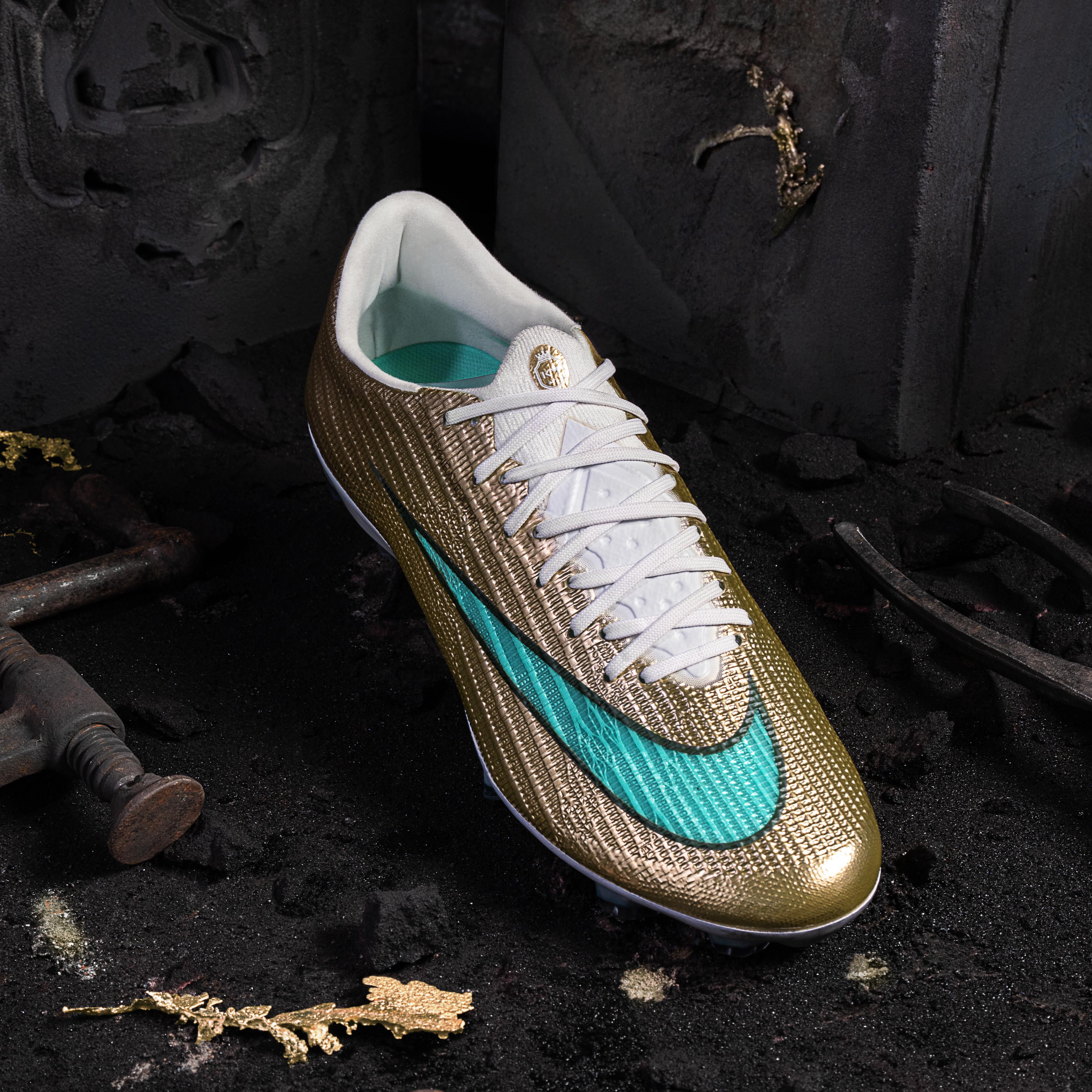A gold soccer cleat with a teal Nike swoosh sits on dark ground with scattered gold flakes and old metal tools.