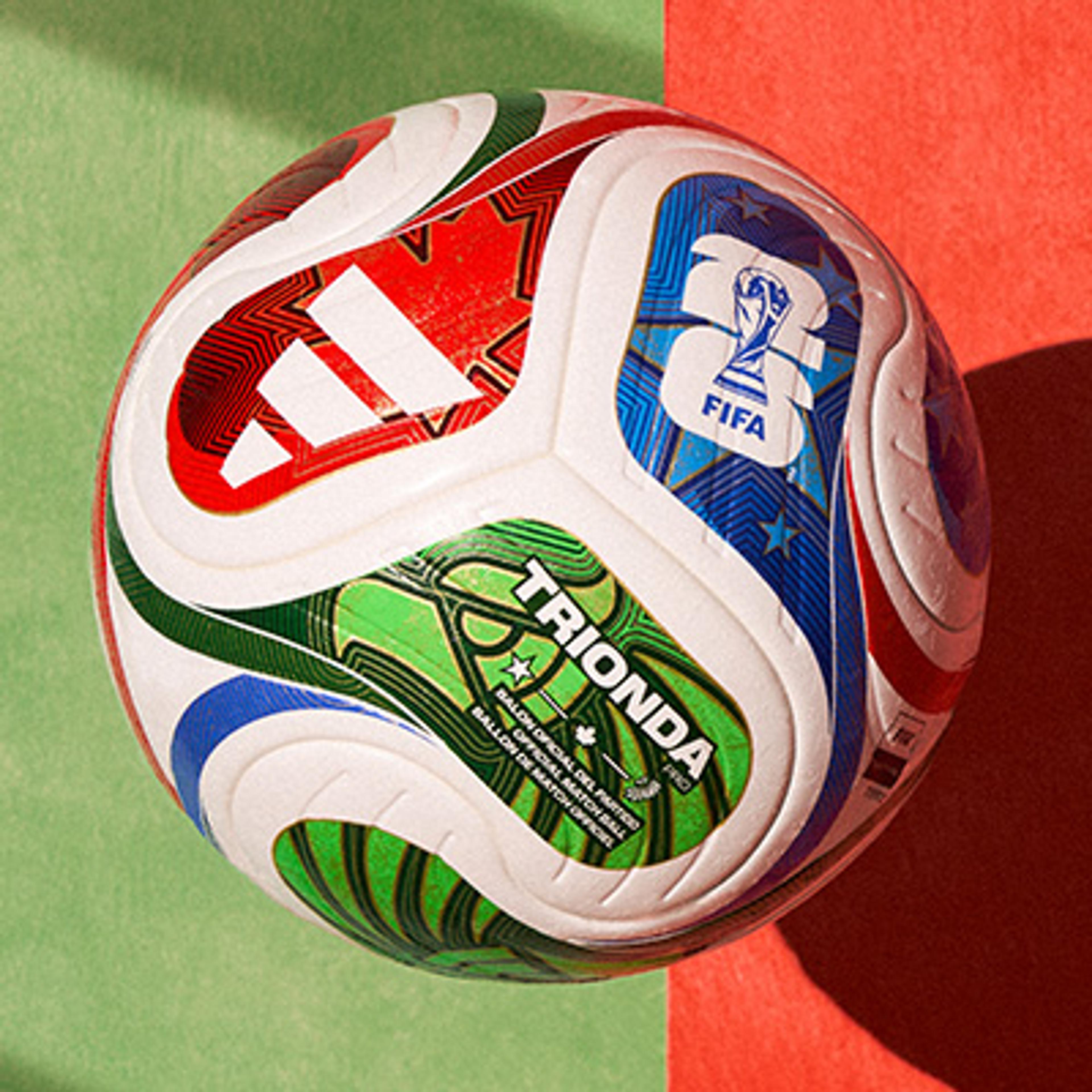 a soccer ball is sitting on top of a green and red surface .