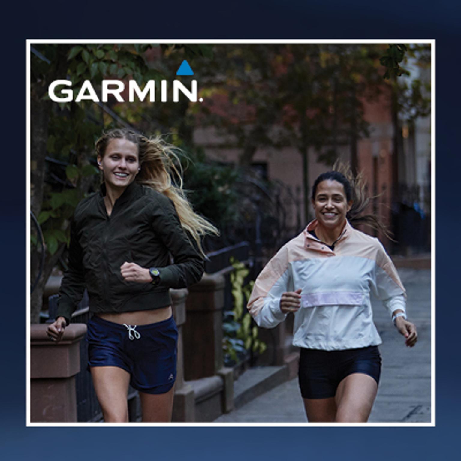 two women are running down a sidewalk on a city street .