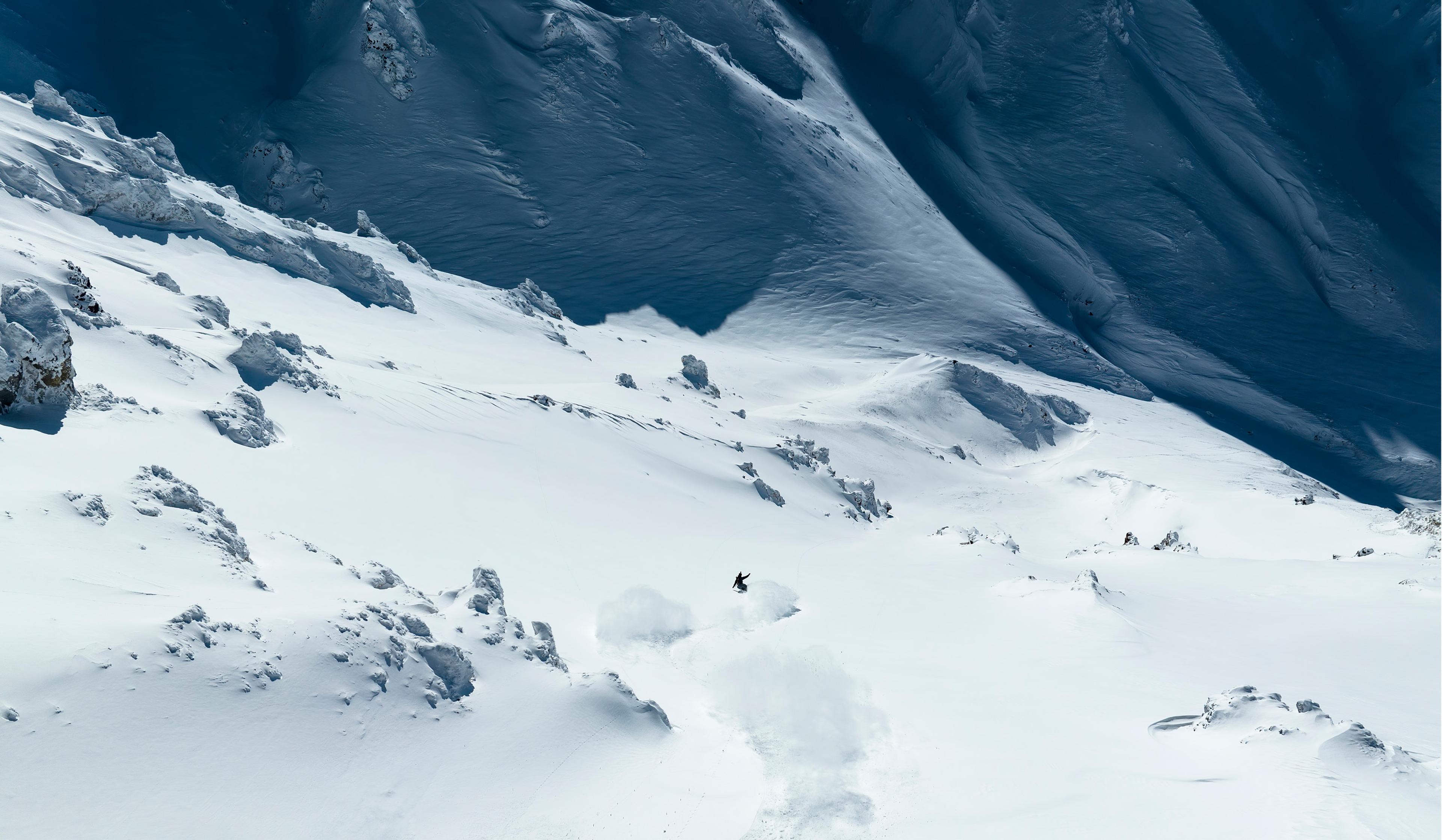 a person is skiing down a snow covered mountain .