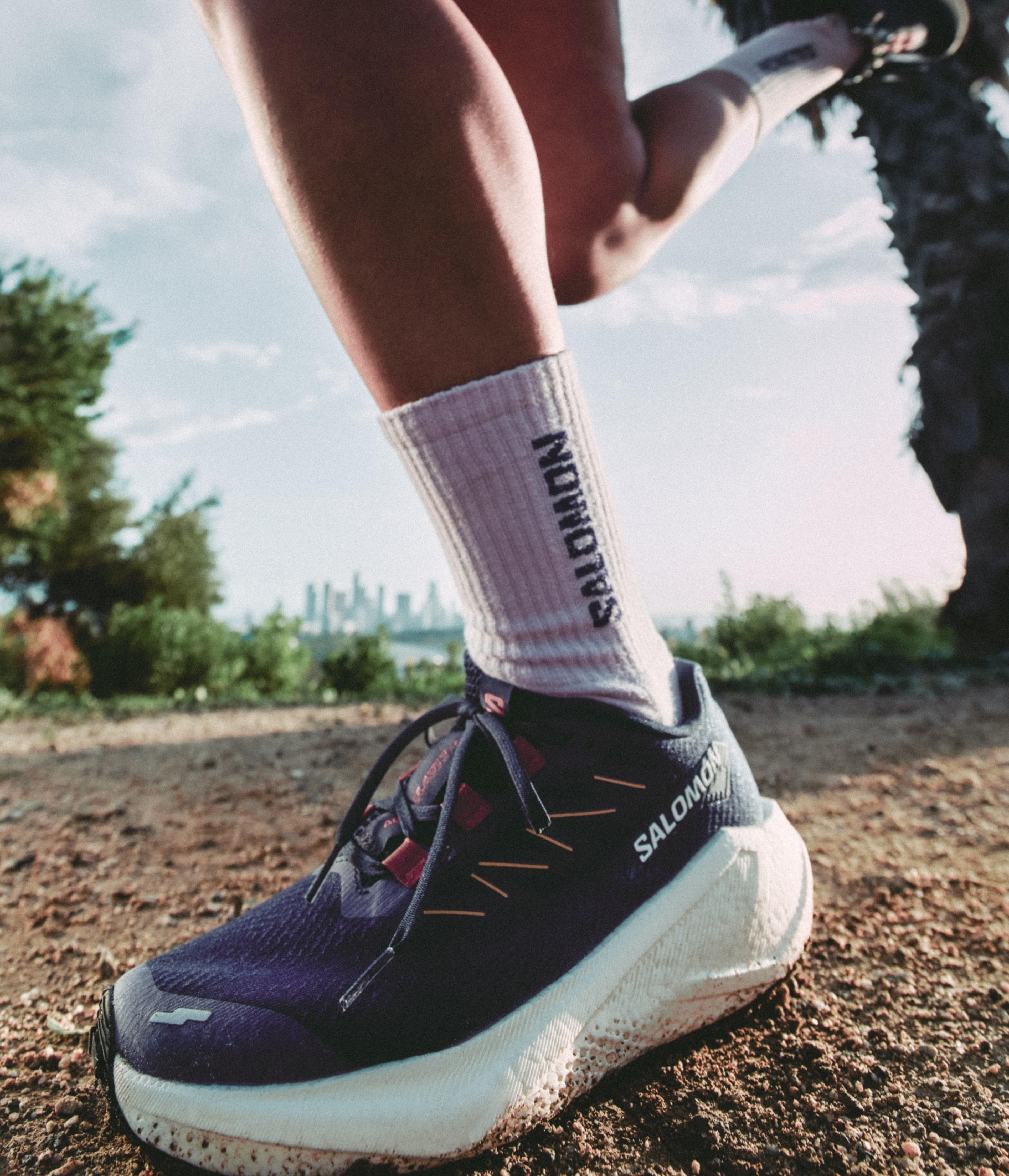 a person wearing a pair of salomon shoes