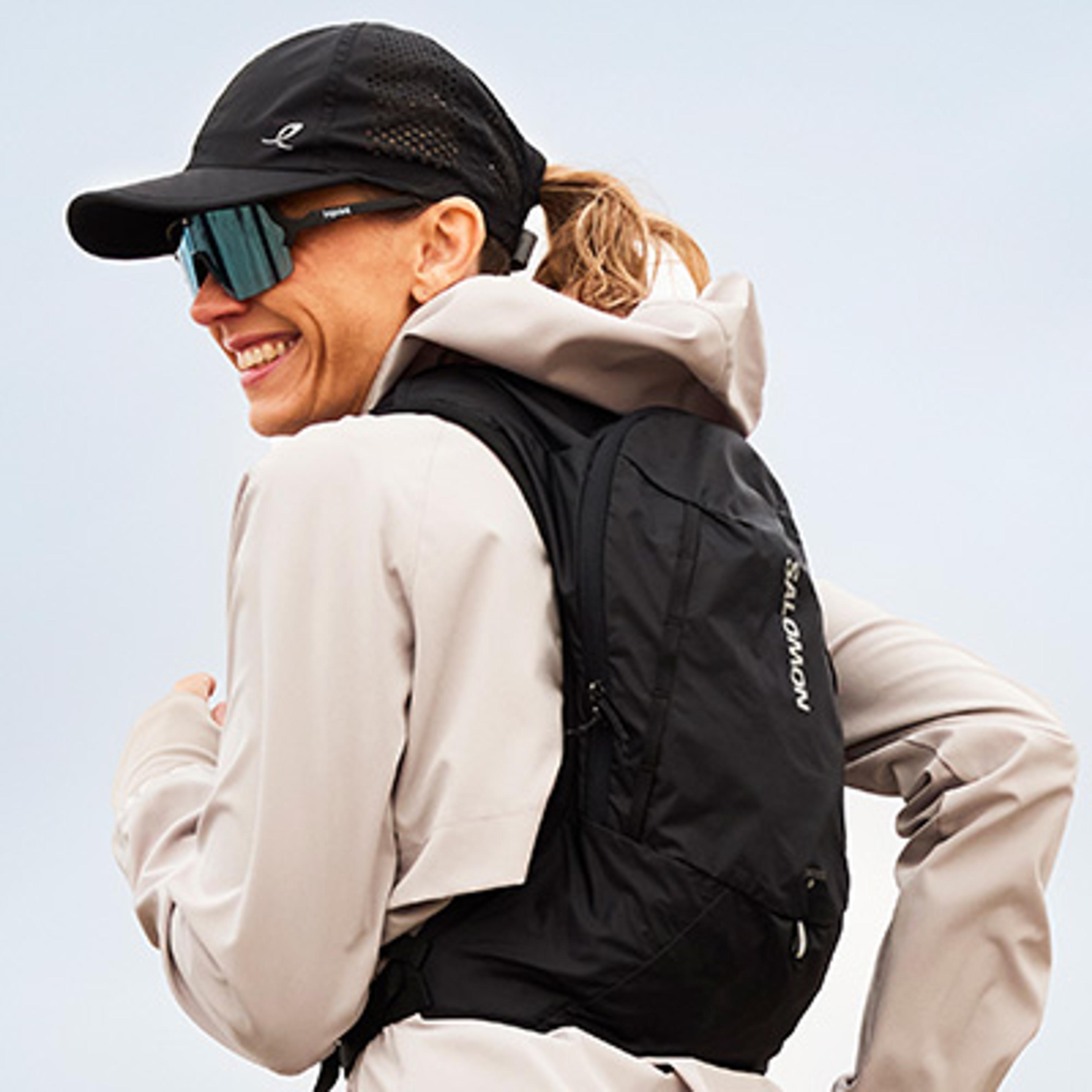 a man is wearing a backpack with a water bottle in it .
