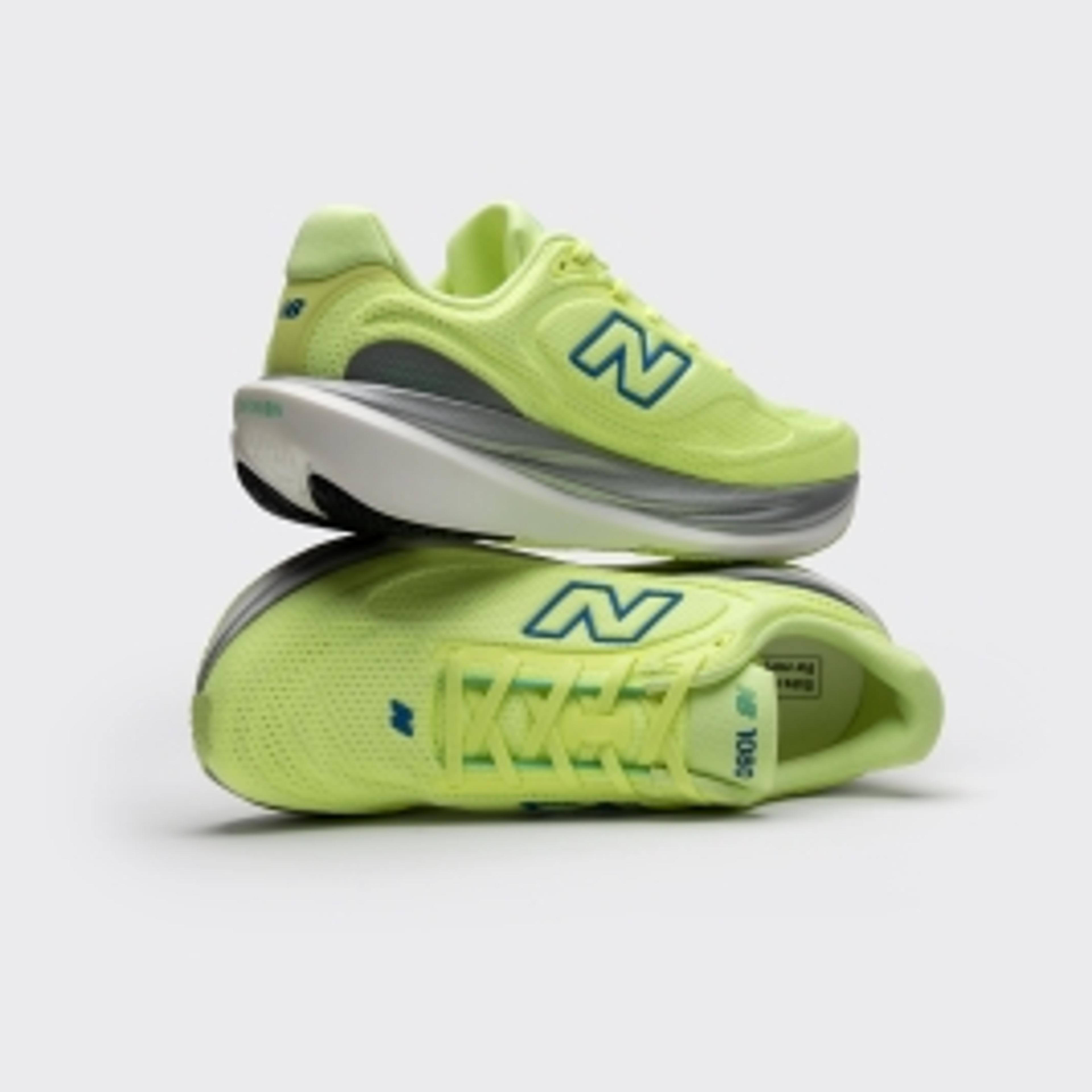 A pair of bright lime green New Balance sneakers, one stacked atop the other.