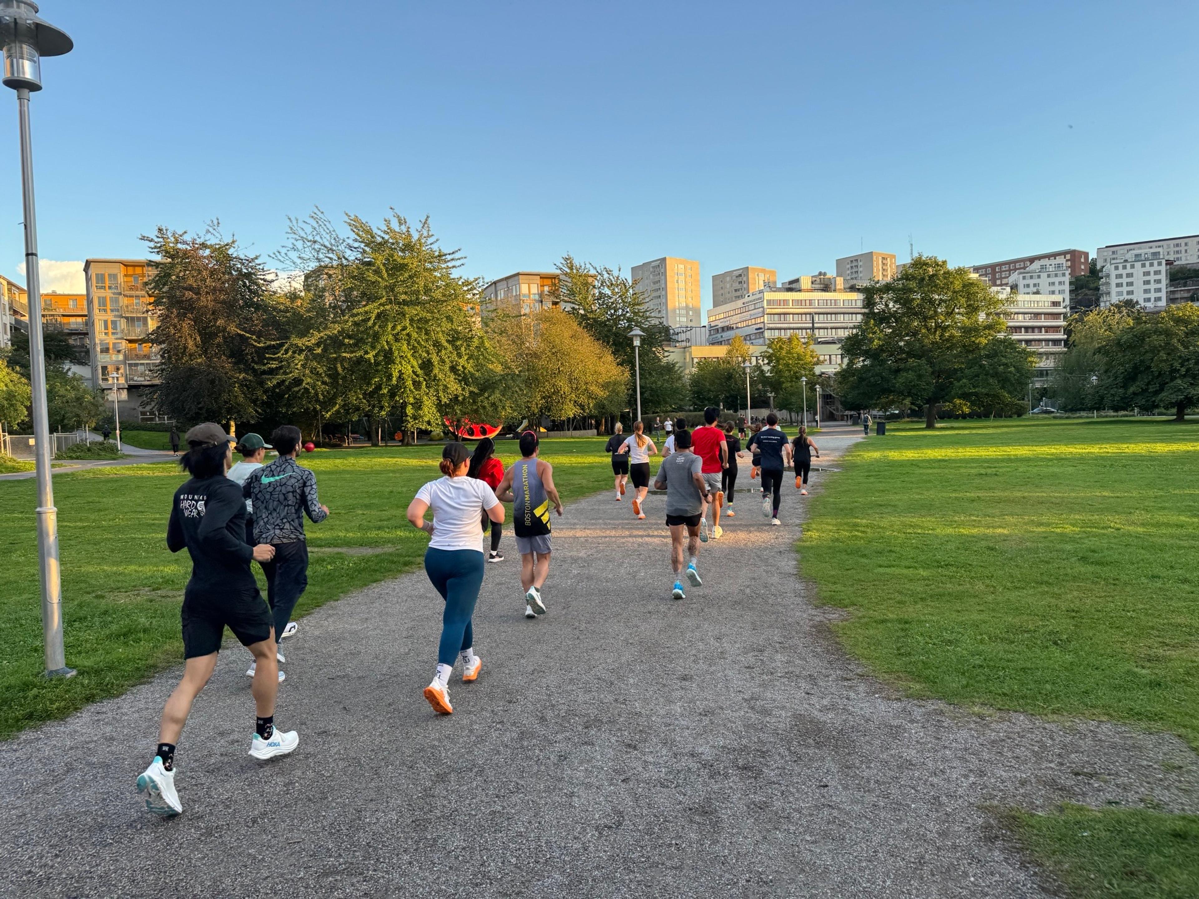 a group of people are running in a park .