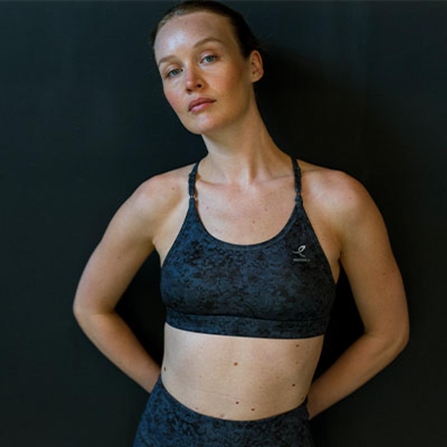 a woman is wearing a black sports bra and black leggings .