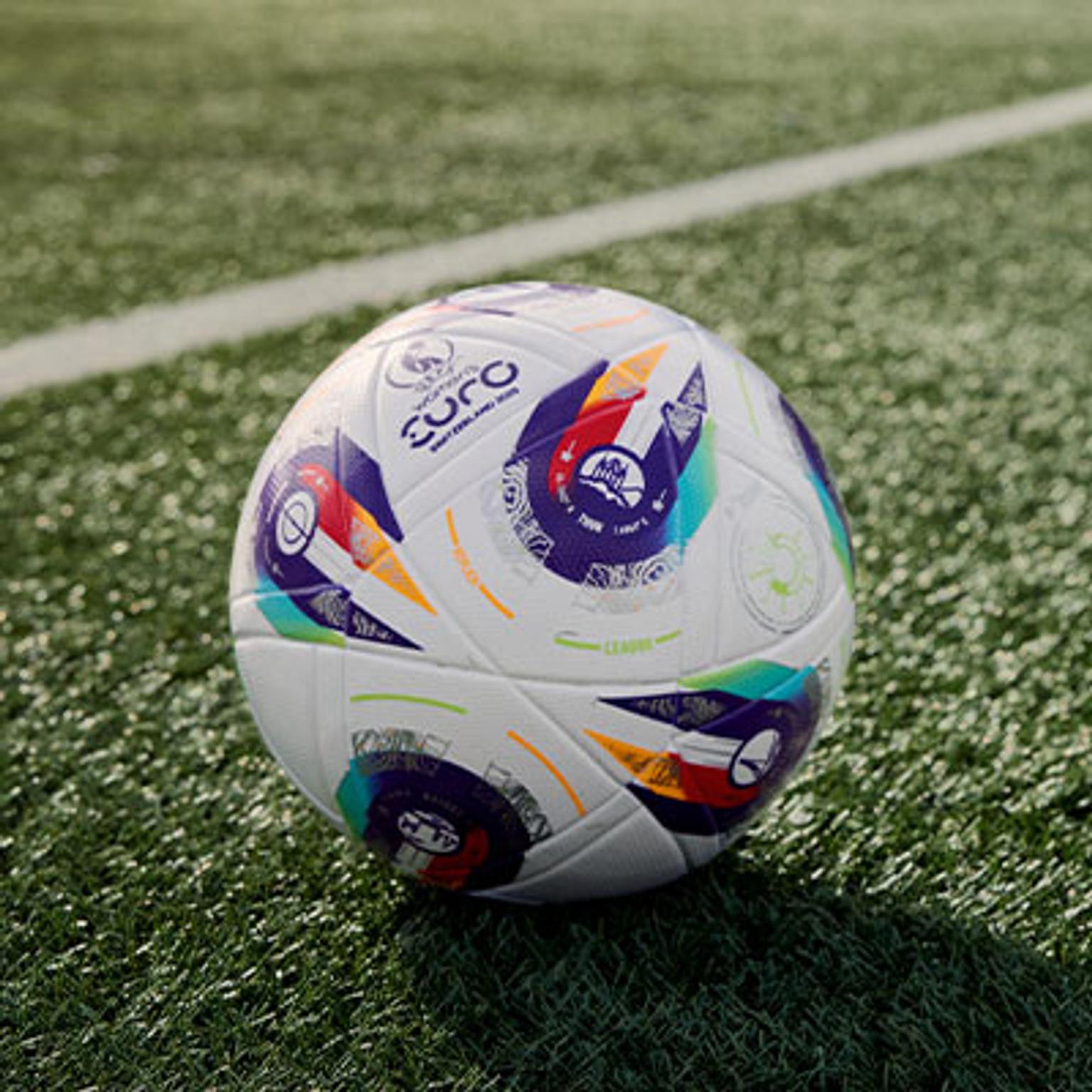 a soccer ball is sitting on top of a lush green field .