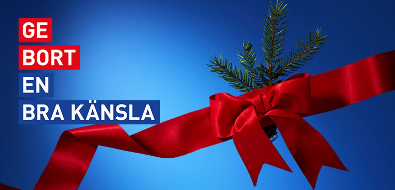 Red ribbon and bow with an evergreen sprig on a blue background, with text "GE BORT EN BRA KÄNSLA".