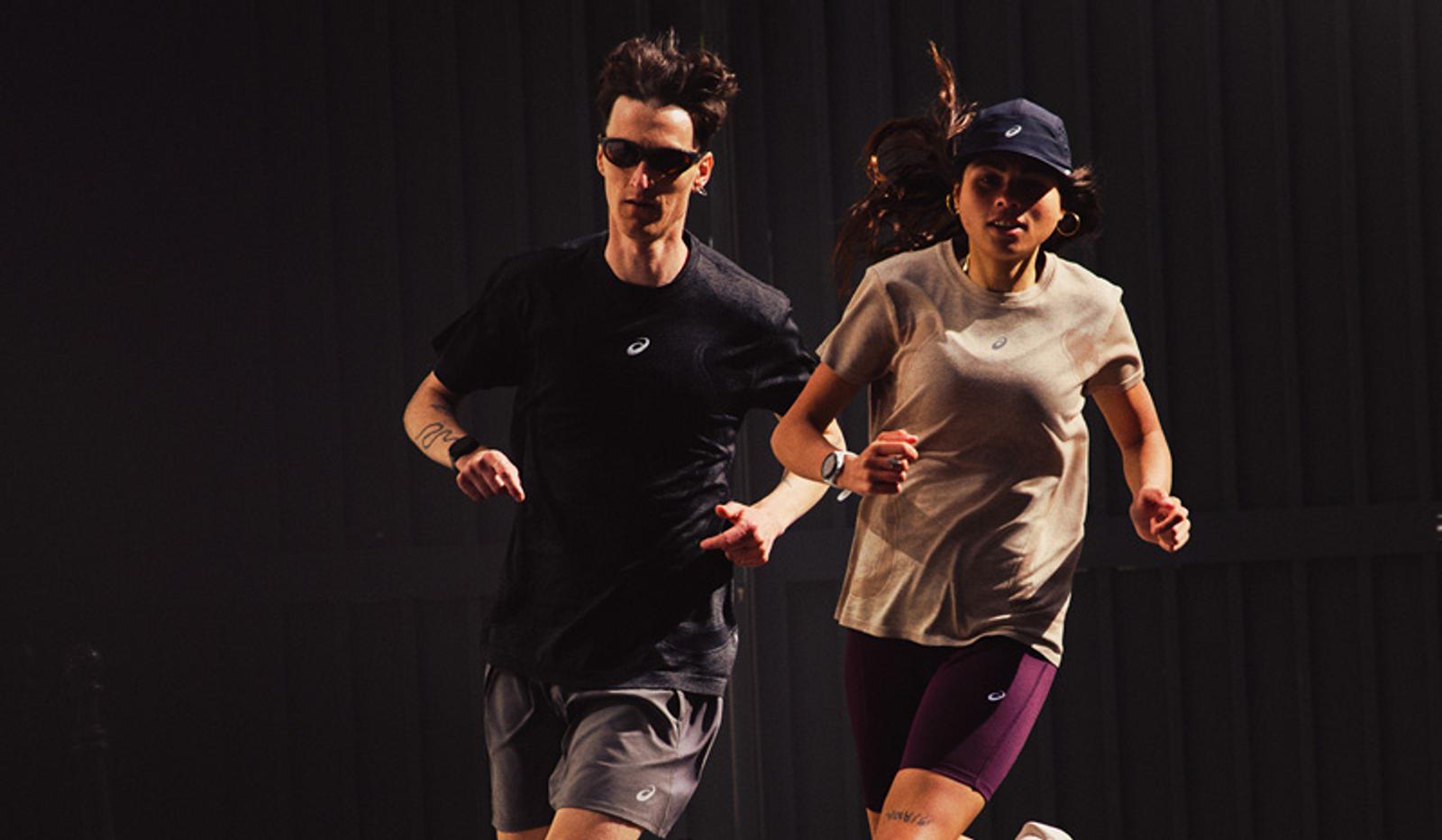 A man and a woman running in athletic wear against a dark background.