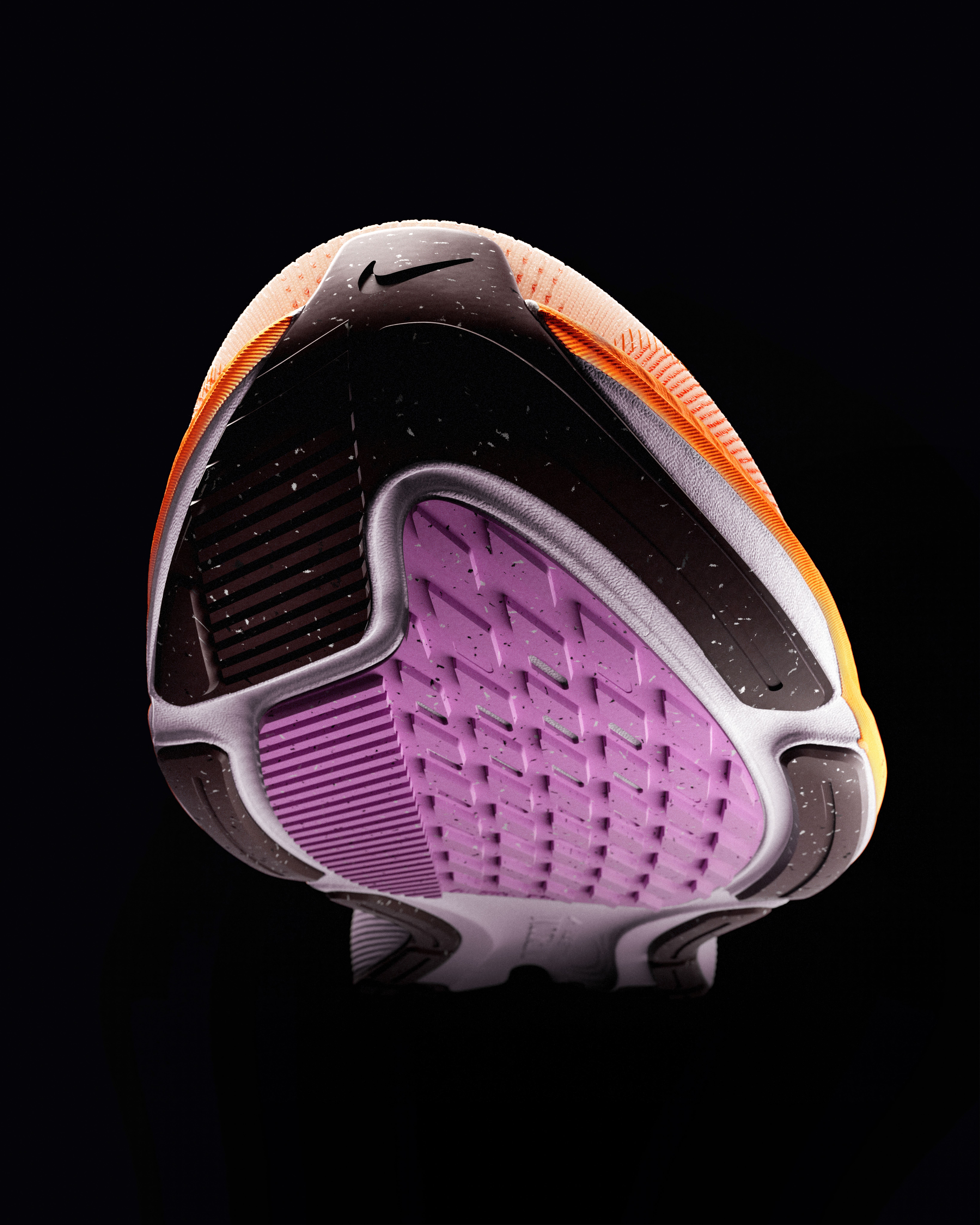 The bottom of a black, orange, and purple Nike sneaker, seen from an upward angle.