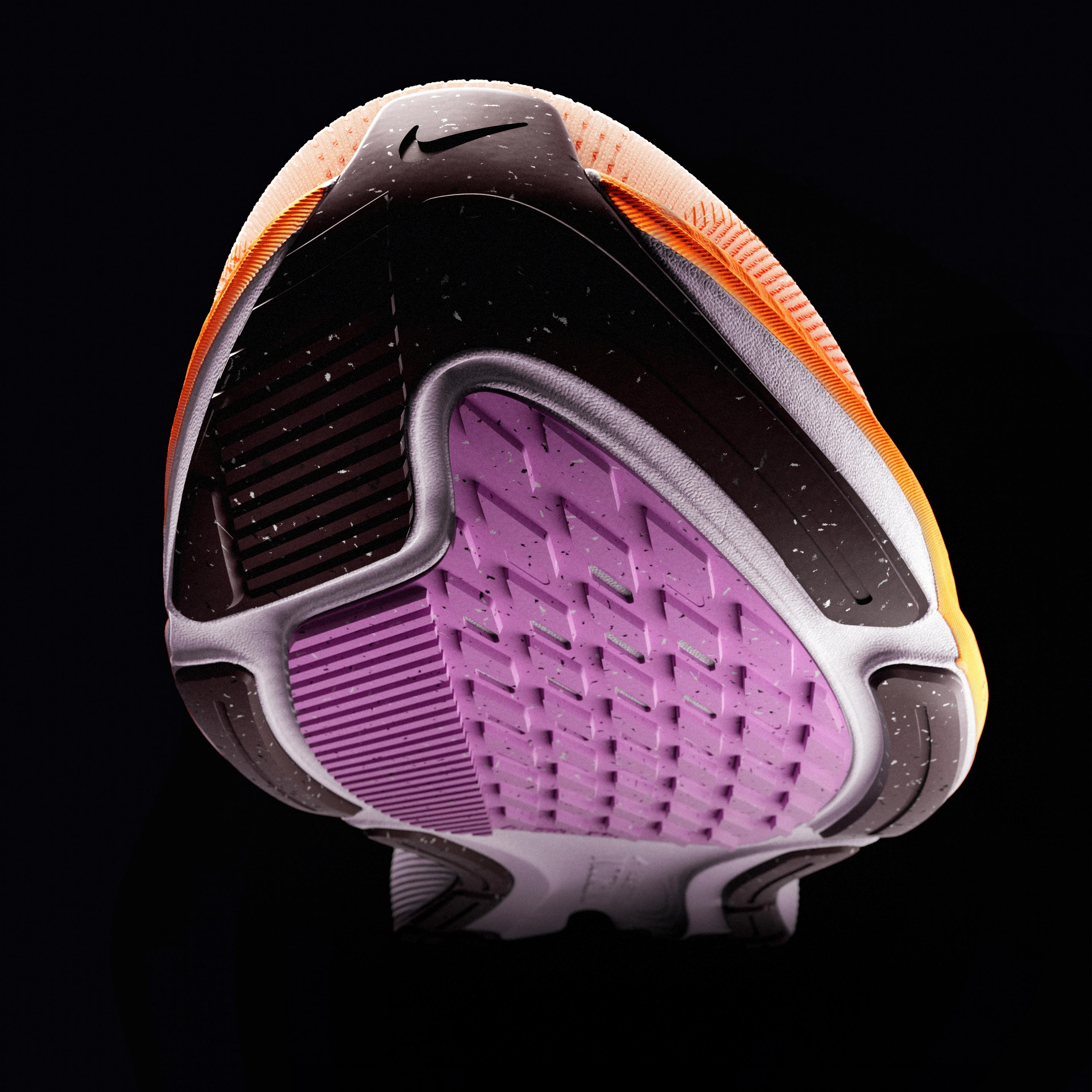 The bottom of a black, orange, and purple Nike sneaker, seen from an upward angle.