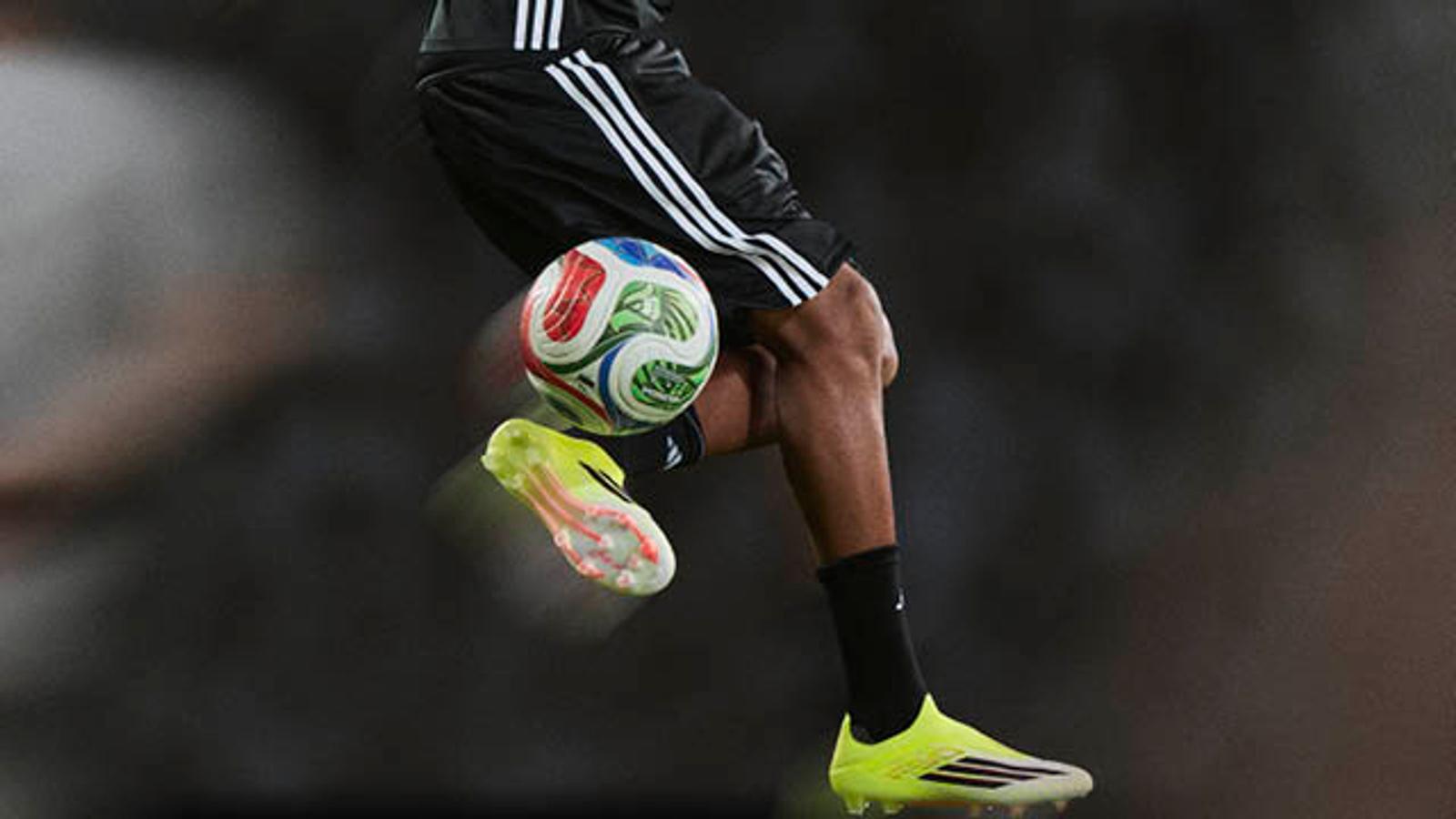 a close up of a person wearing soccer cleats on a field .