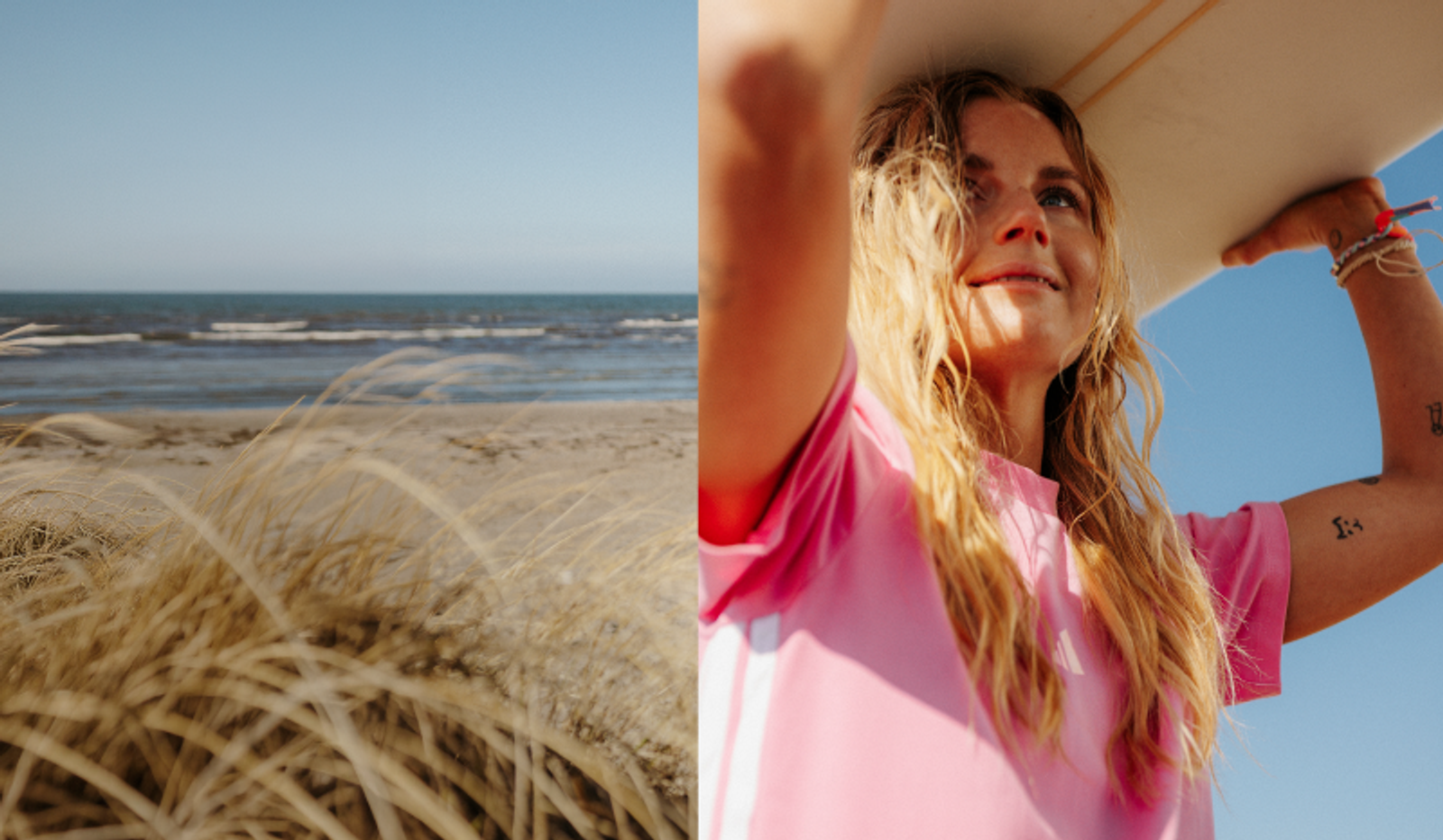 A woman holding a surfboard on her head, seen next to a beach with ocean and dry grass.