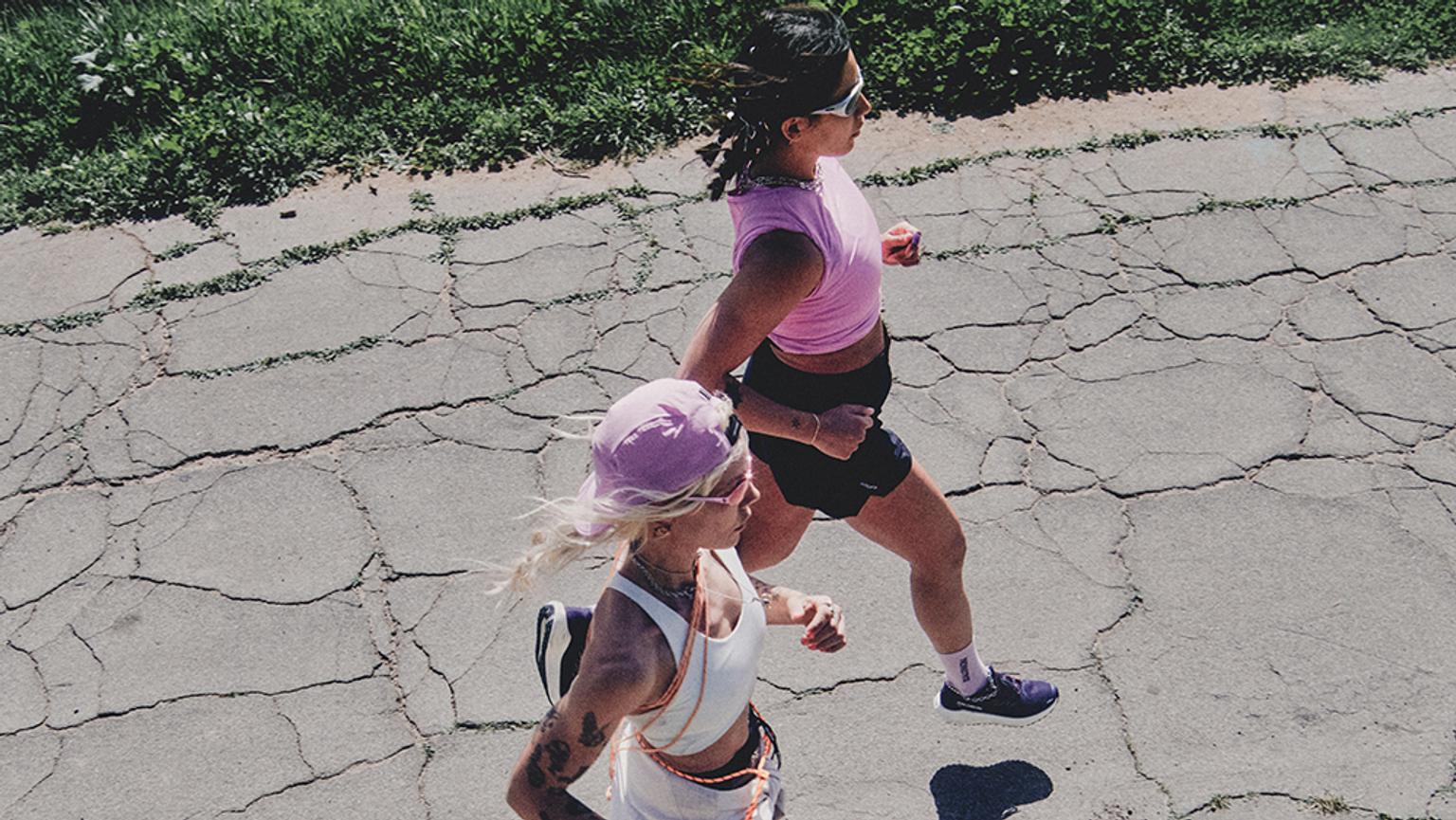 two women are running on a cracked road .