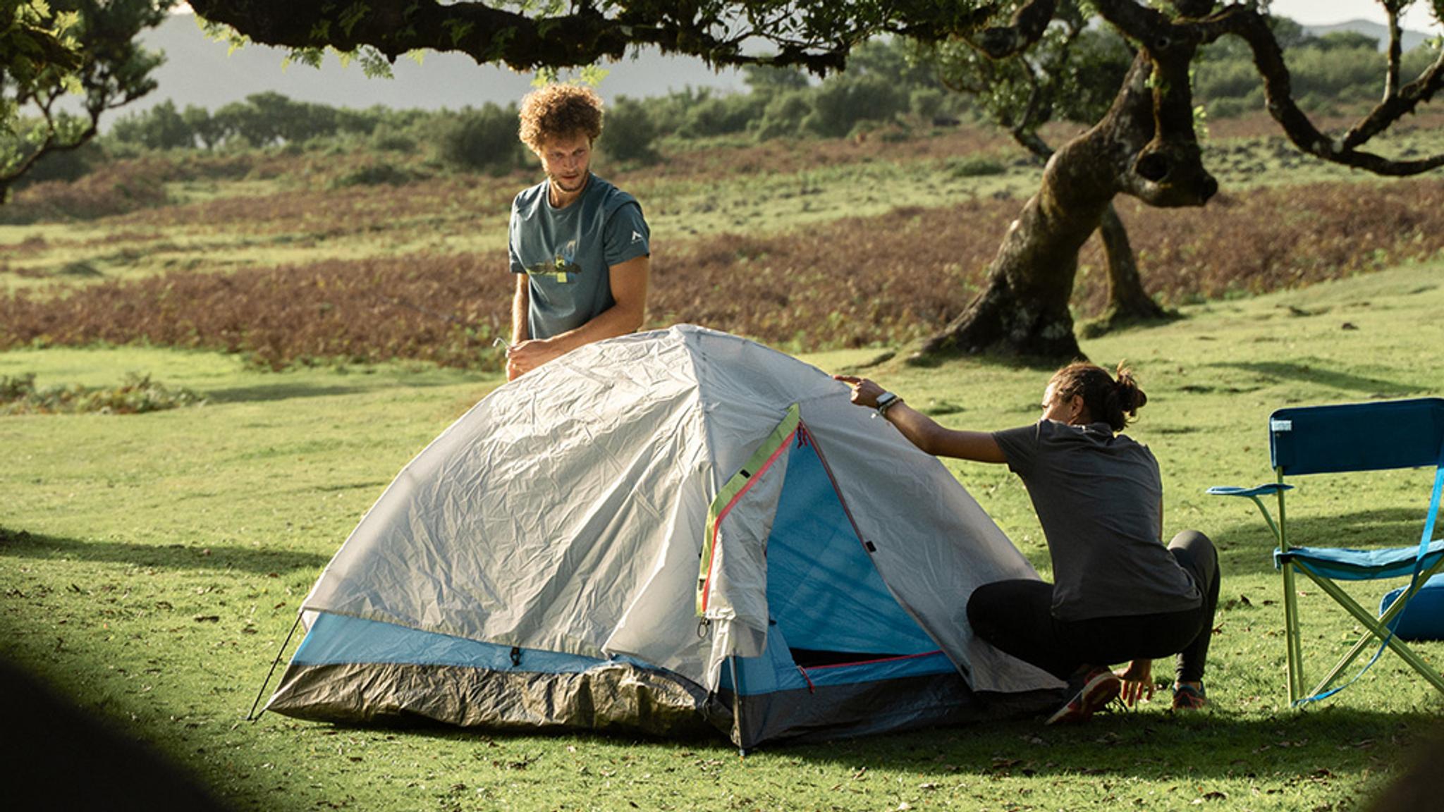 Två personer som testar och jämför tält.