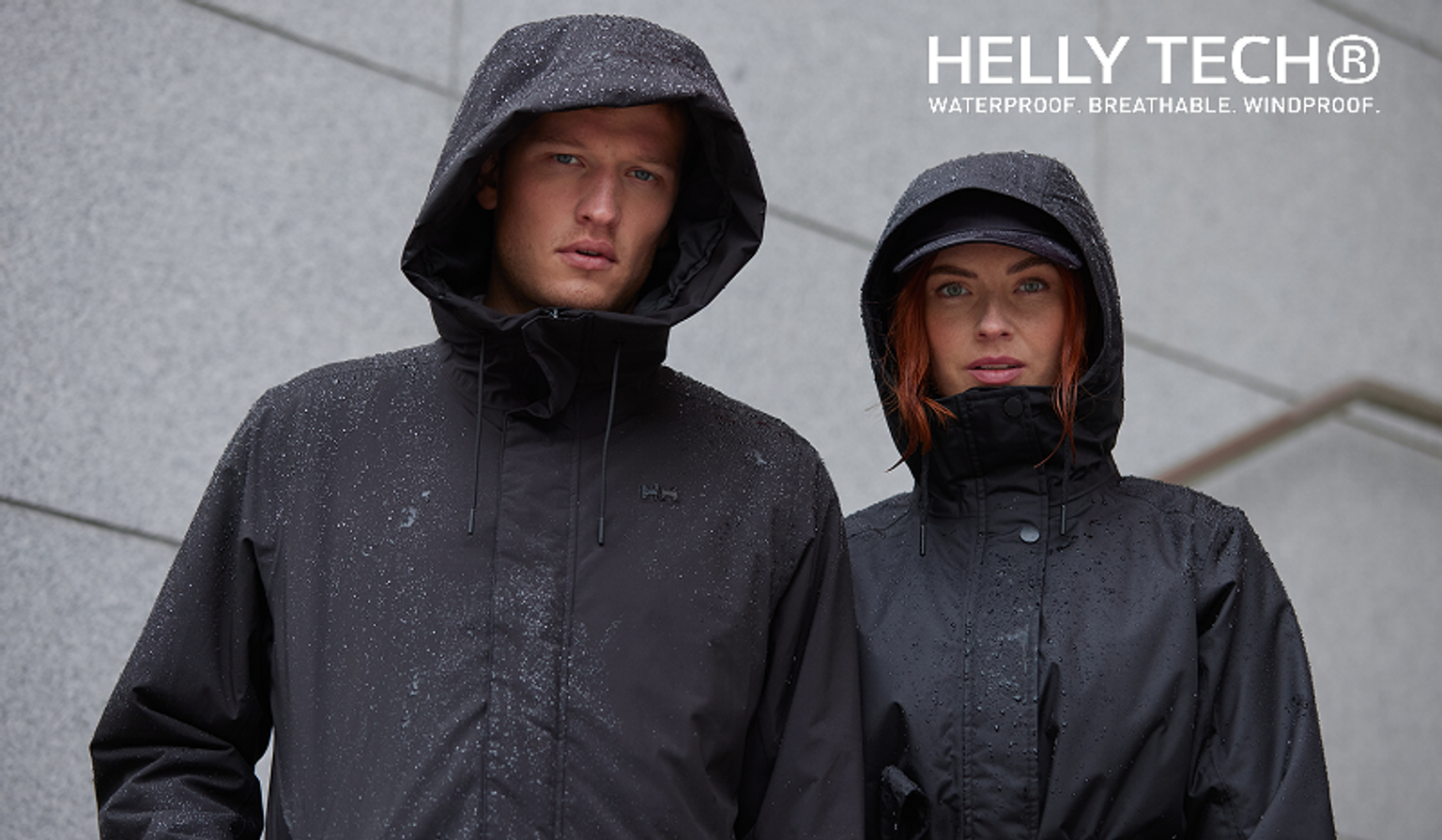 a man and a woman wearing black jackets that say helly tech
