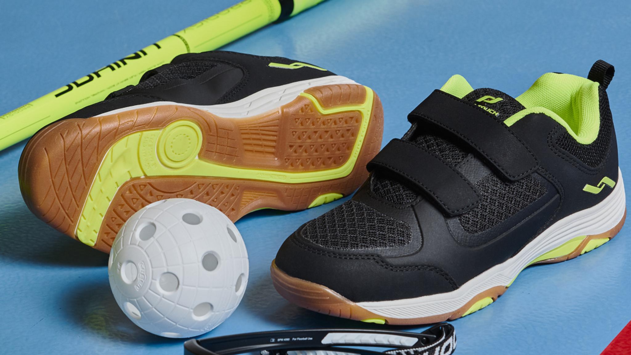 a pair of shoes , a ball , a stick and glasses are on a blue surface .