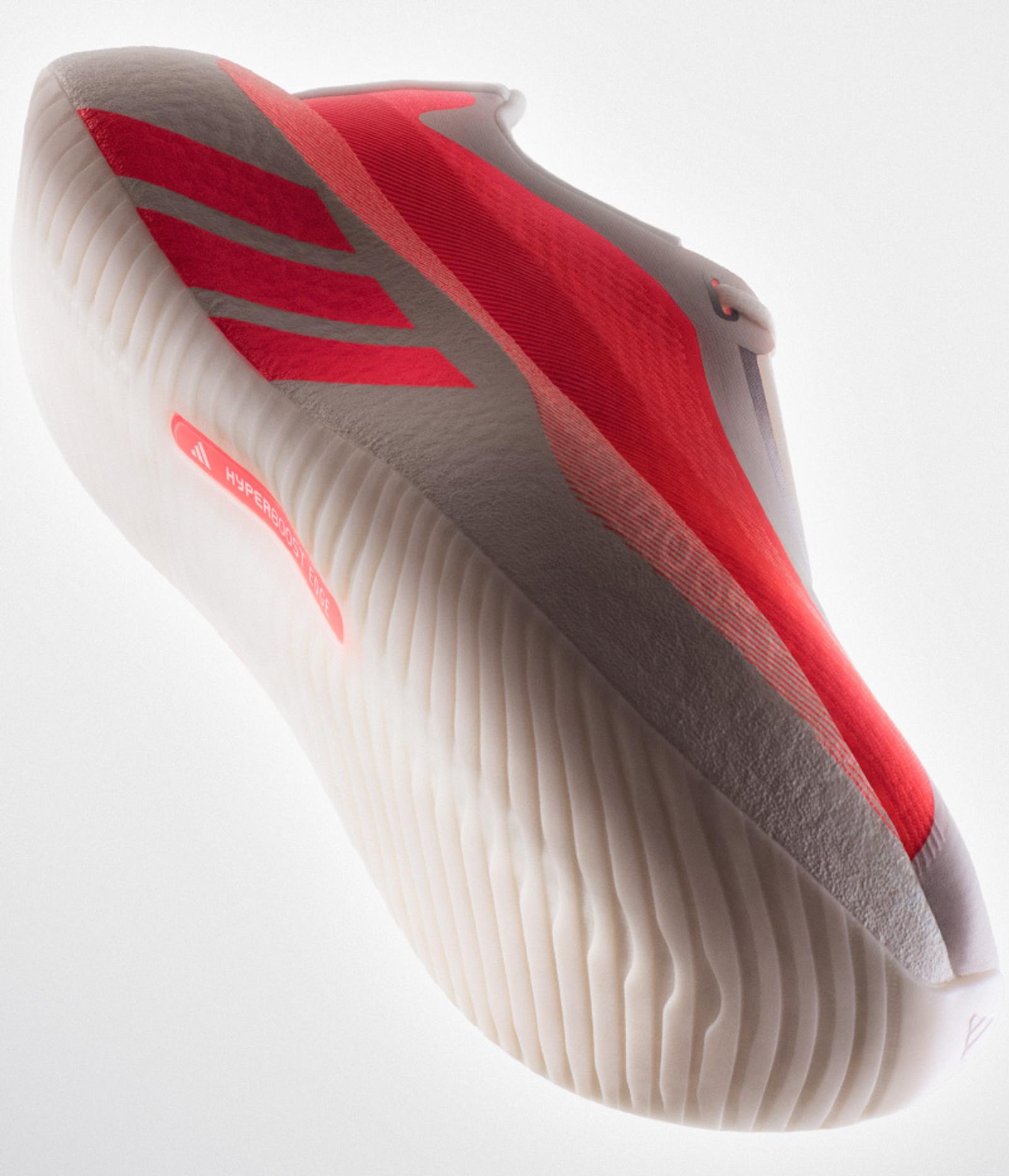 An Adidas athletic shoe with a light gray upper, bright coral accents including three stripes, and a textured cream midsole.