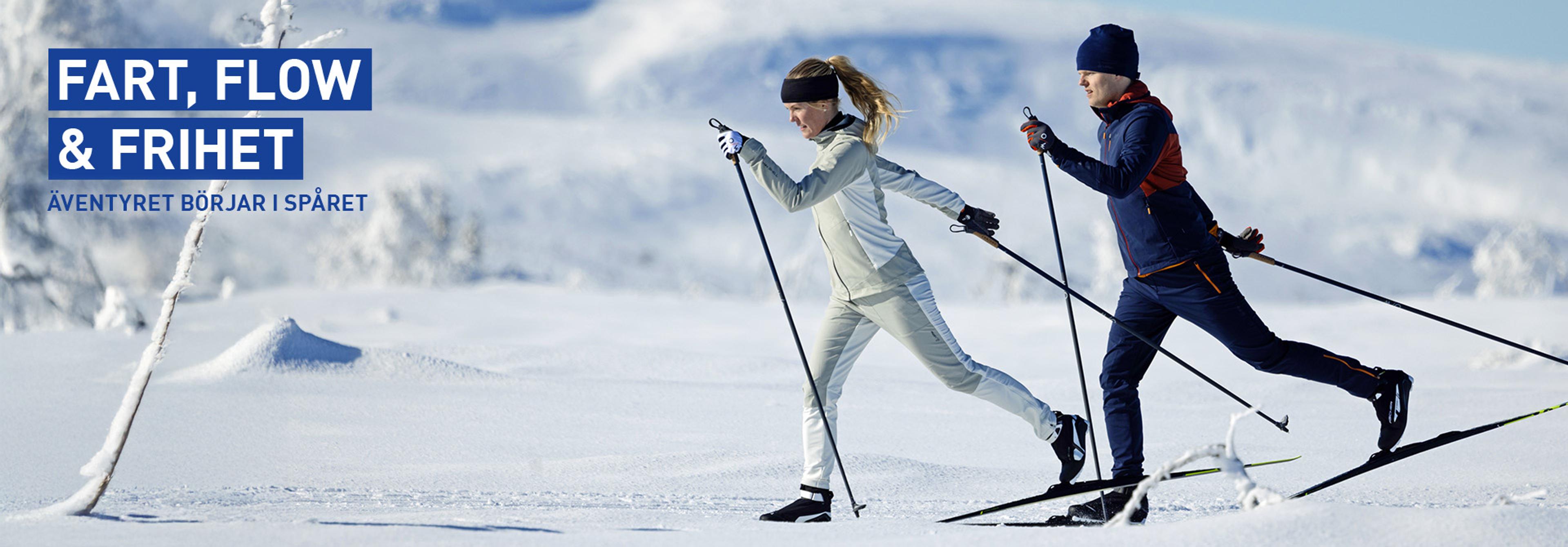 a man and a woman are cross country skiing in the snow .