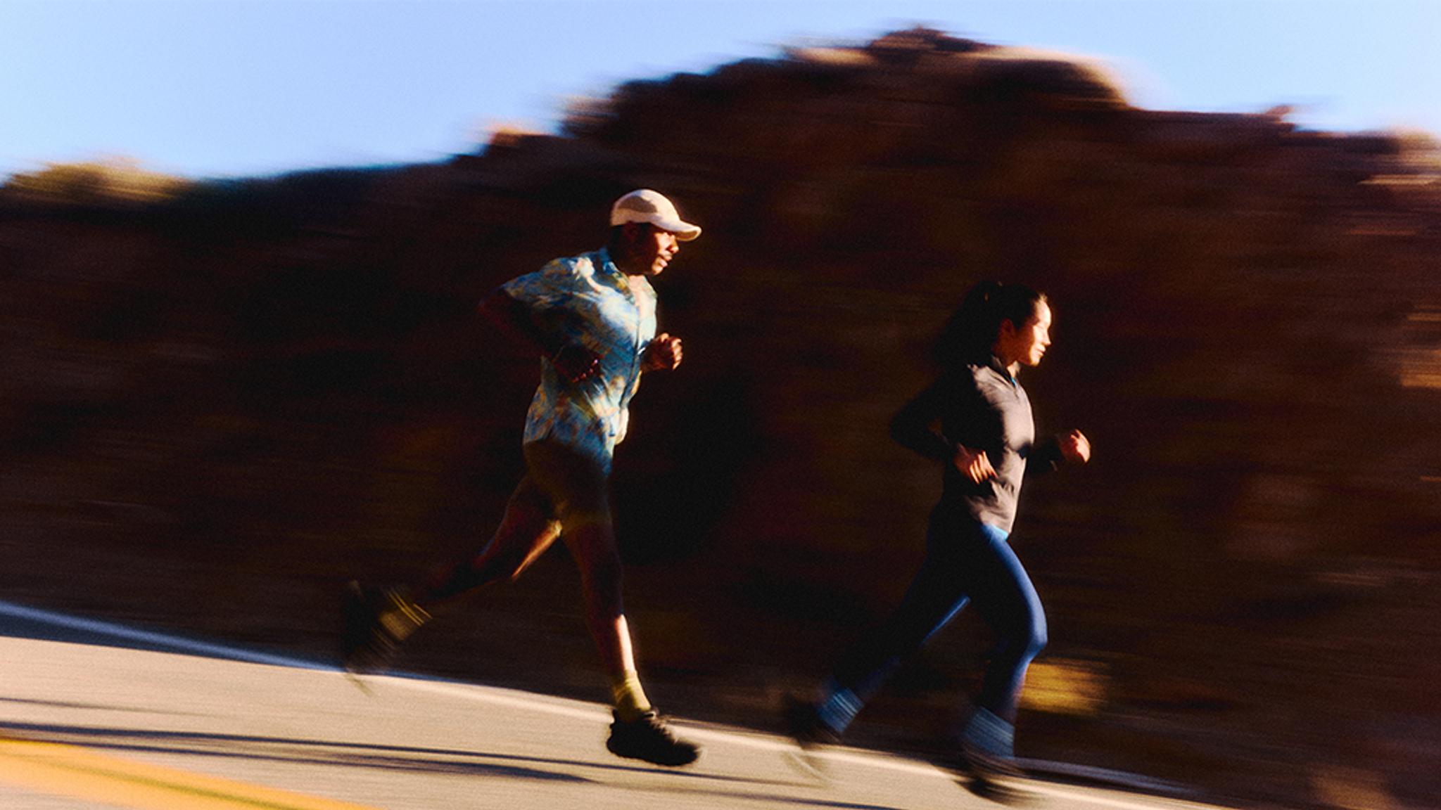 a man and a woman are running down a road .