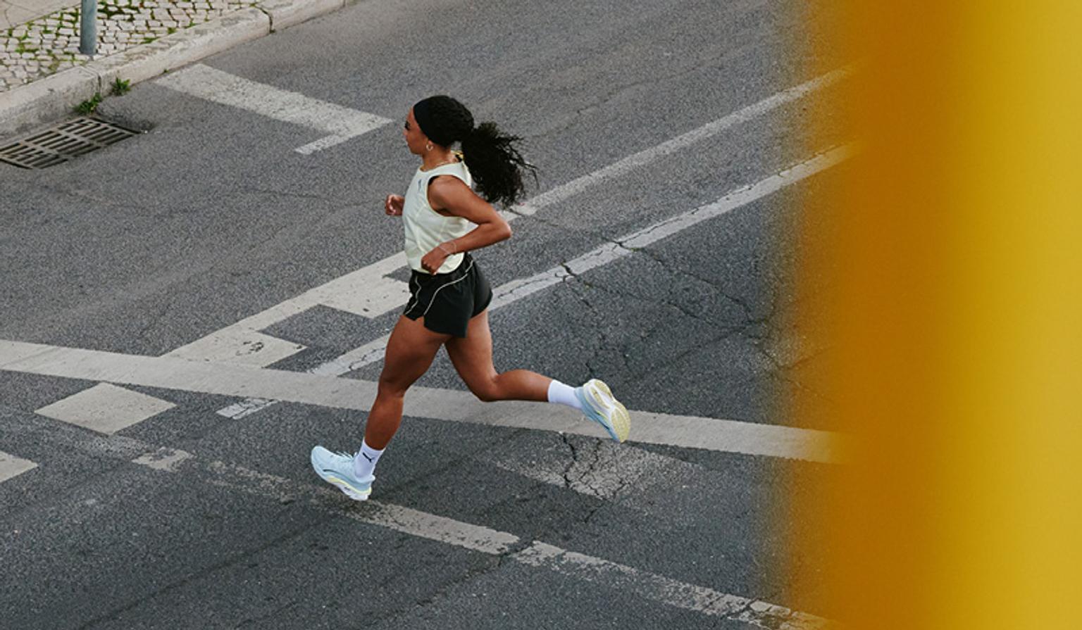 a woman is running across a street at an intersection .