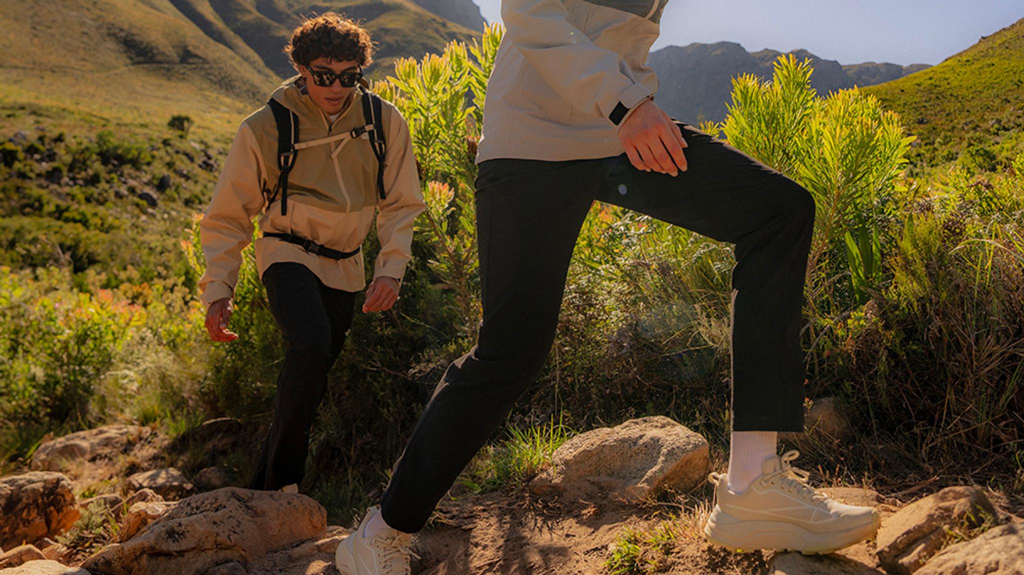 a group of people are hiking in the mountains .