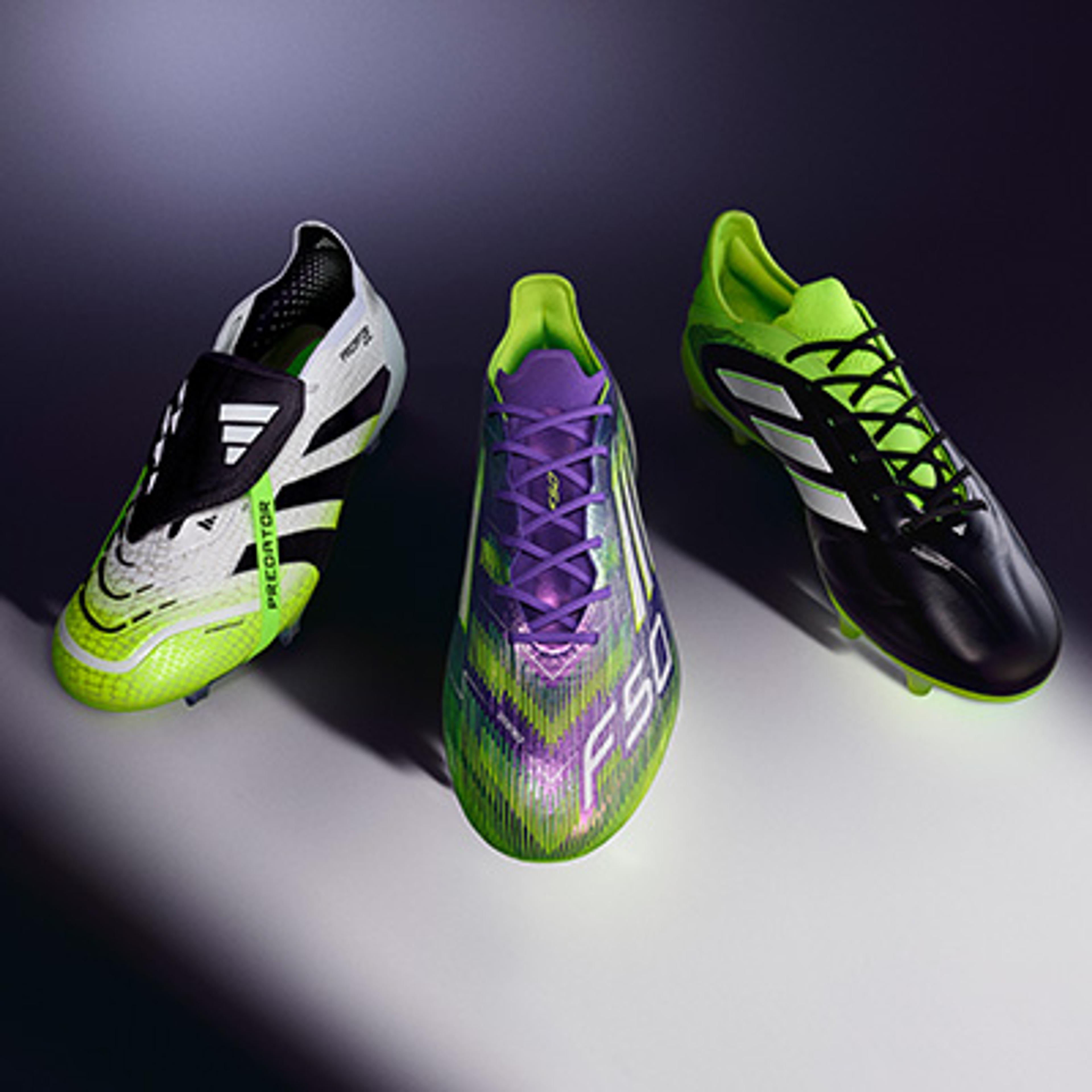 three pairs of soccer cleats are sitting on top of each other on a table .