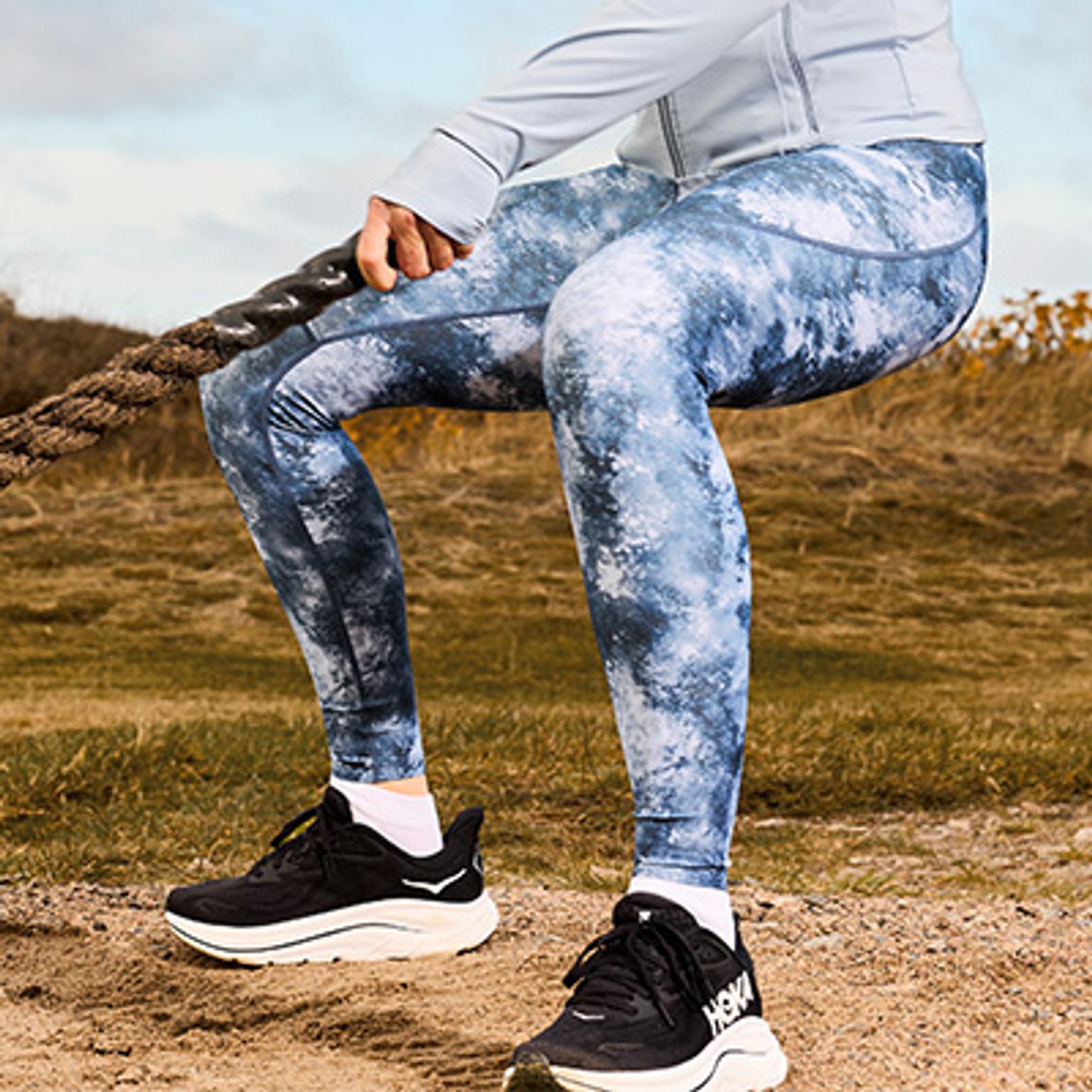 a woman is holding a medicine ball in her hand in a gym .