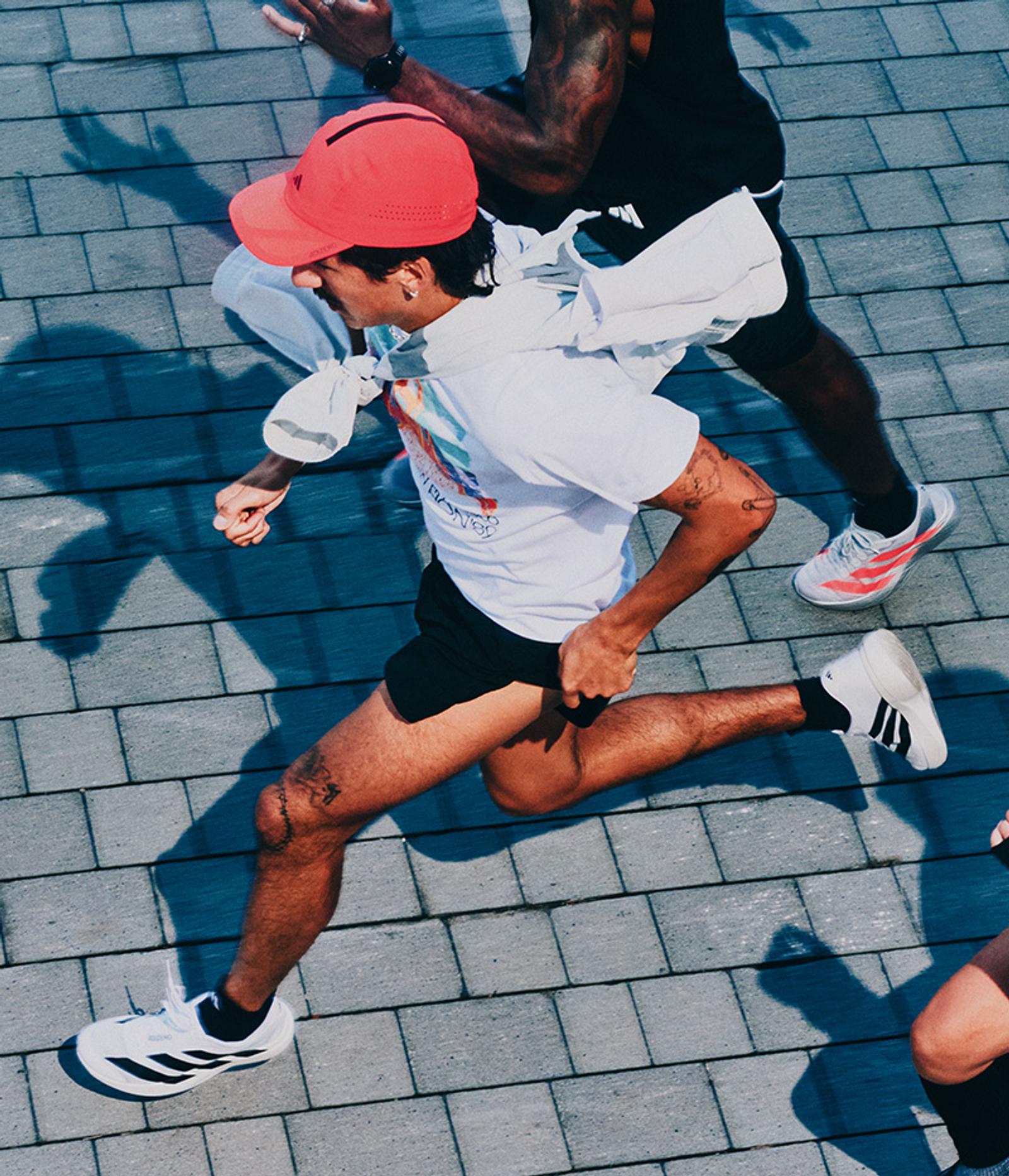 a woman is running on a sidewalk in front of a white wall .