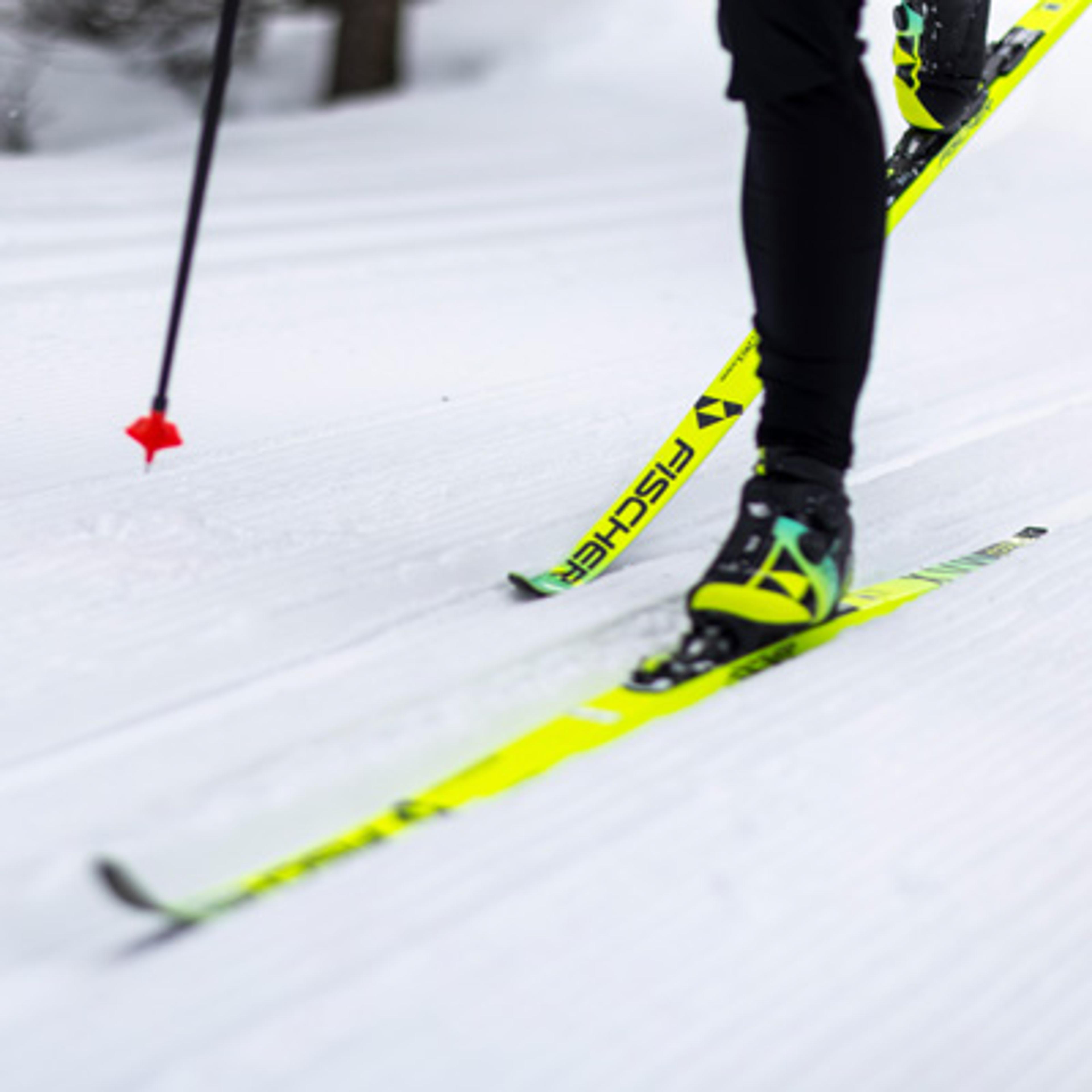 a person is cross country skiing on a snowy trail .