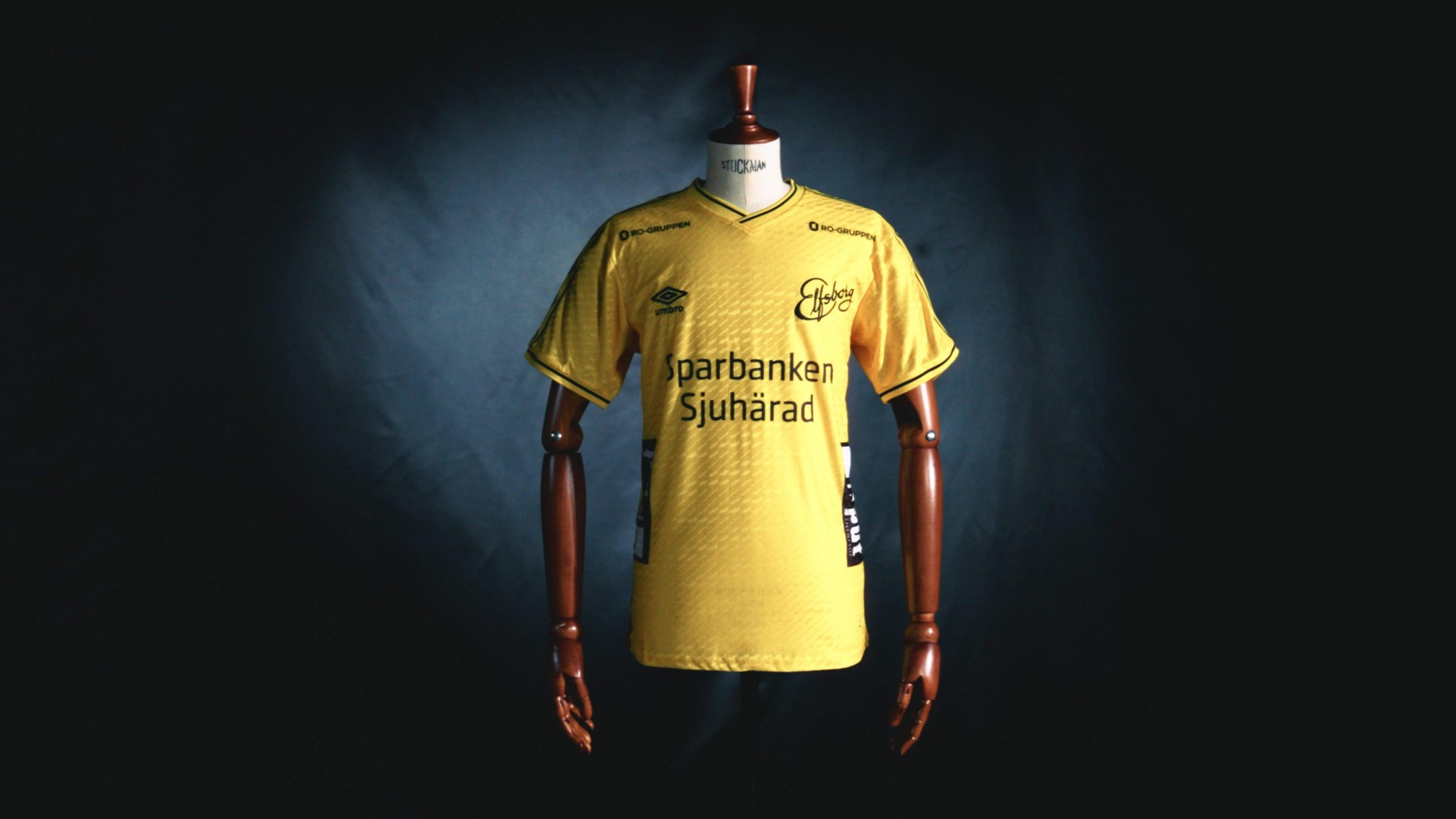 Yellow soccer jersey with black Umbro and Sparbanken Sjuhärad logos displayed on a mannequin.