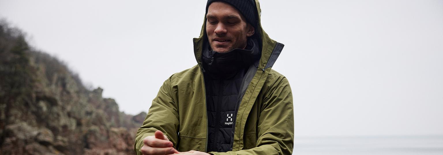 Man och kvinna ute och går iklädd skaljacka