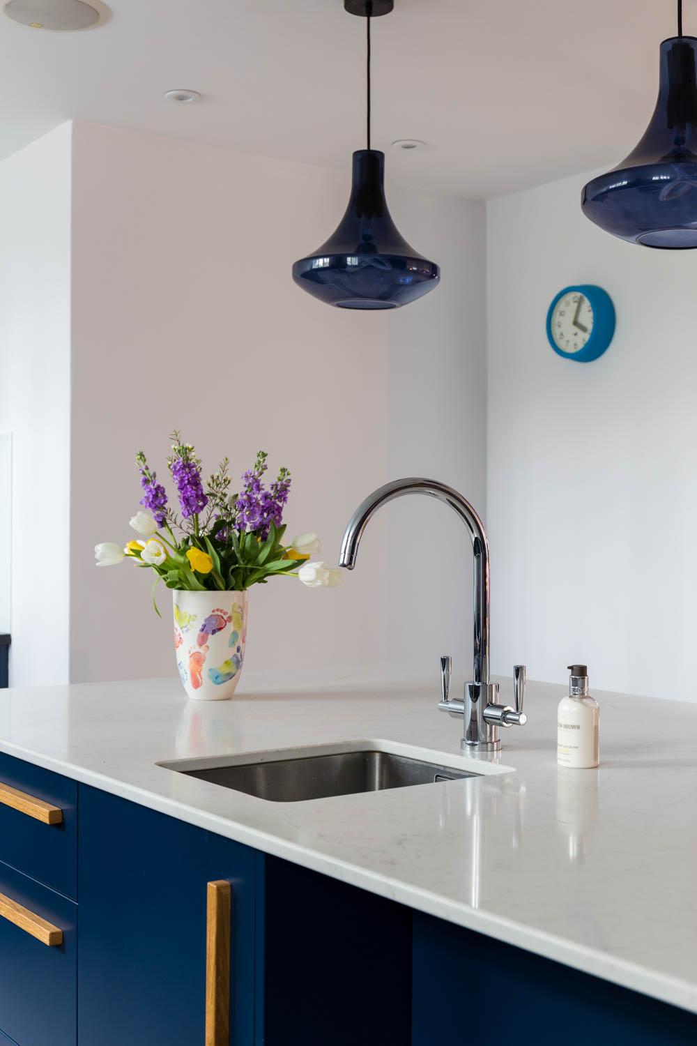 Stainless steel appliances blend seamlessly with light countertops, amplifying the minimalist aesthetic and modern vibe.