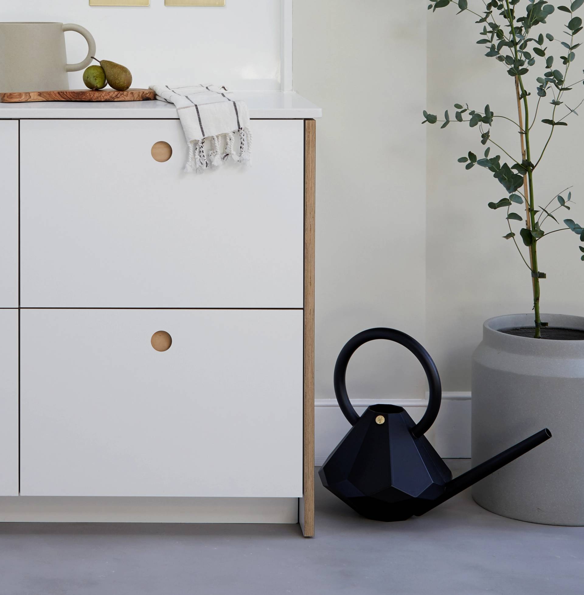 Light-colored, natural wood surface with subtle grain patterns and smooth texture, displaying faint variations in shade and gentle swirling lines.