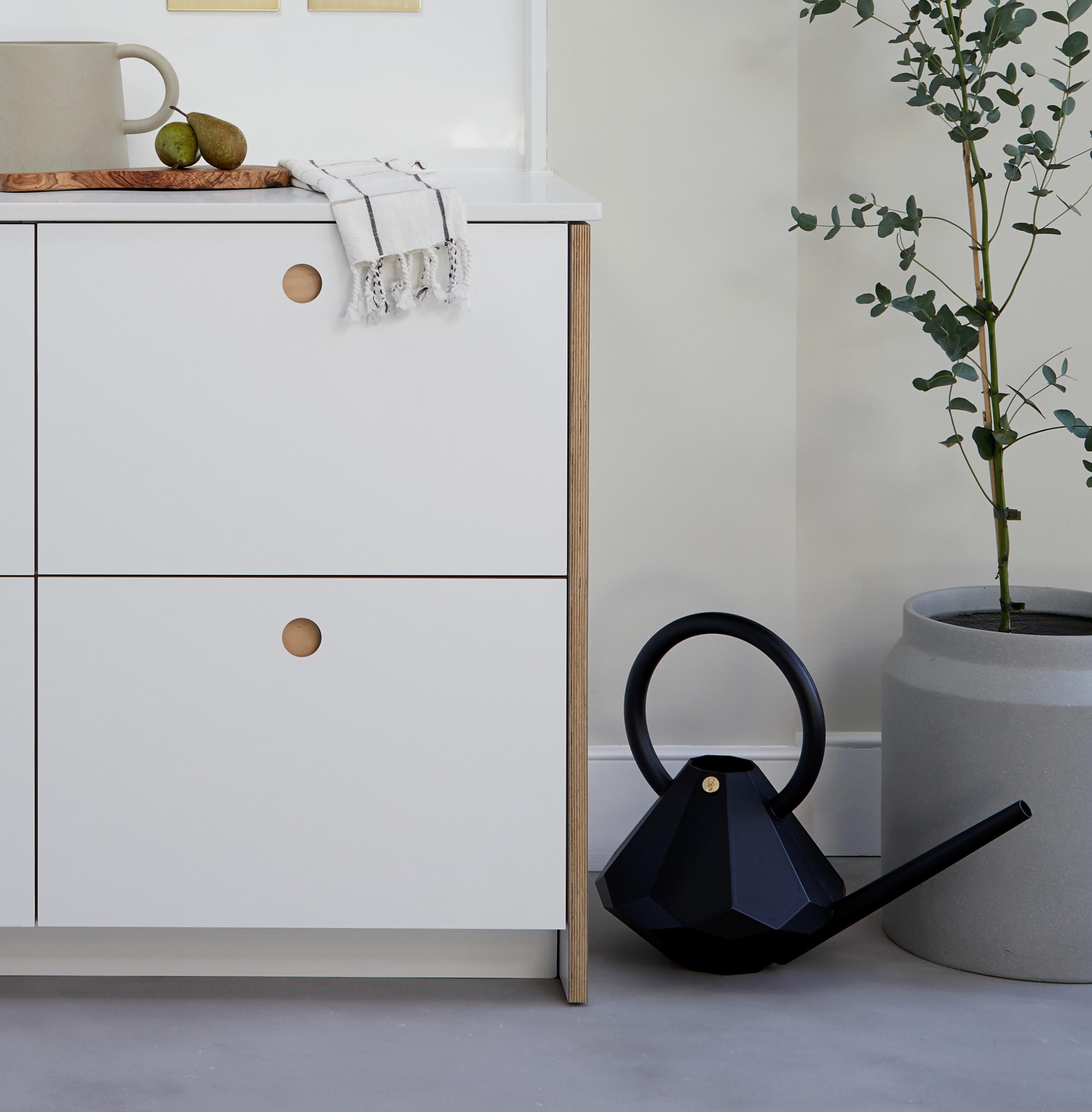 Light-colored, natural wood surface with subtle grain patterns and smooth texture, displaying faint variations in shade and gentle swirling lines.