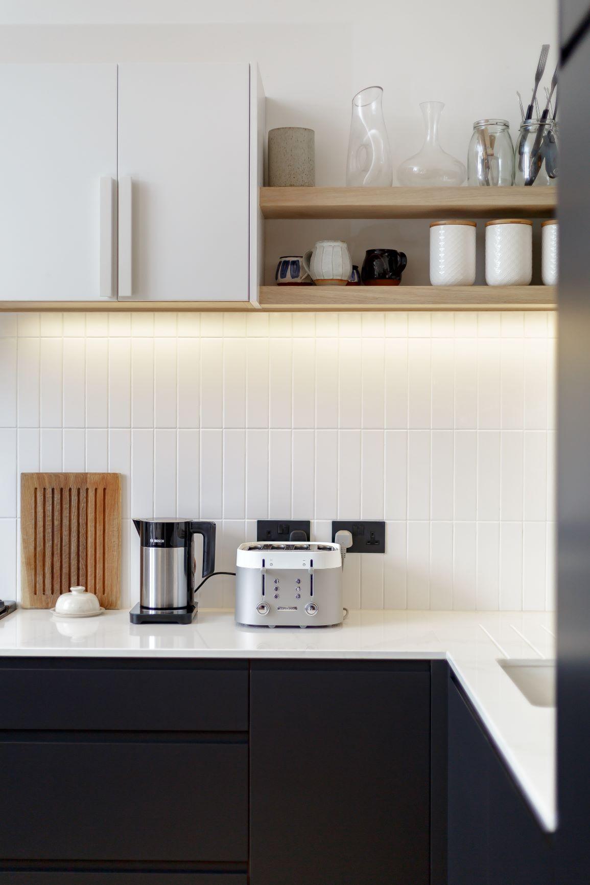 Discover the dramatic beauty of this stunning Edinburgh kitchen, featuring Oyster Catcher painted cabinets contrasting with Holkham Frost white units, worktops, and wall tiles.