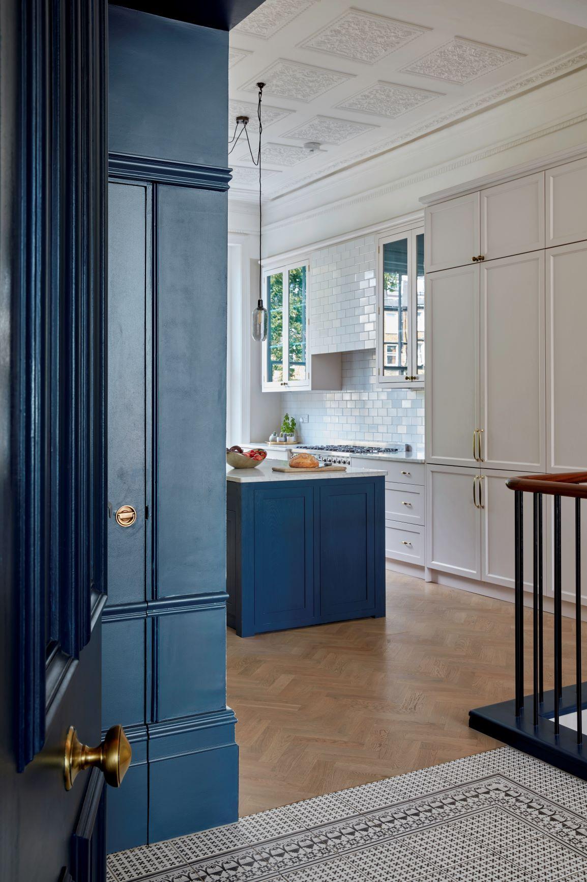 As you step through the entrance door, you are greeted by a spacious, sun-drenched kitchen, where white and blue shaker-style cupboards gracefully meet the eye. The kitchen's generous dimensions provide ample space for culinary creativity and family gatherings, while the harmonious blend of white and blue evokes a sense of tranquility and inviting warmth.