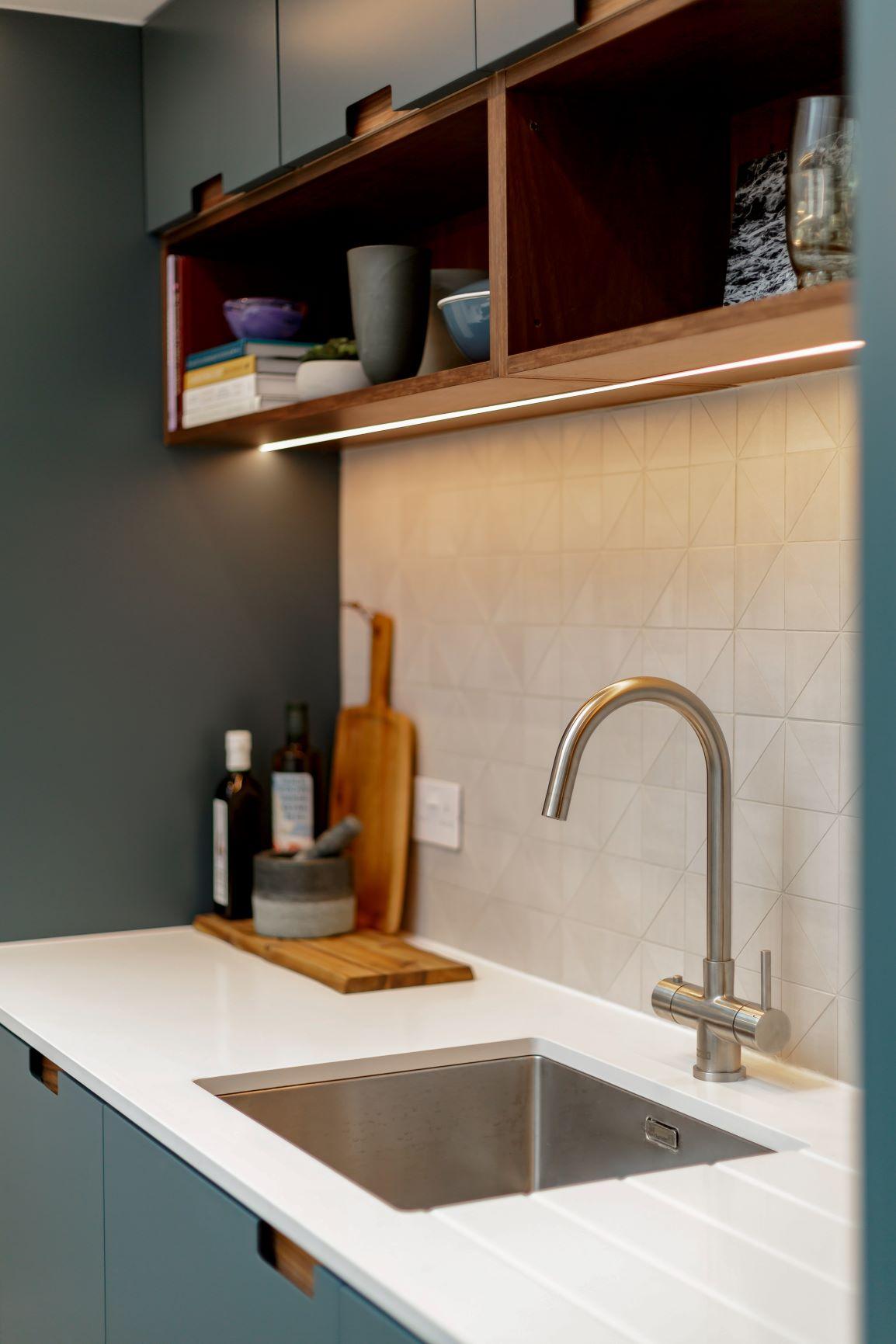 Recessed LED strips illuminate the Castle Mews kitchen, adding a touch of sparkle and highlighting the countertops and cabinets. The subtle lighting creates a cozy and inviting ambiance, making it a delightful space to prepare meals or simply relax.