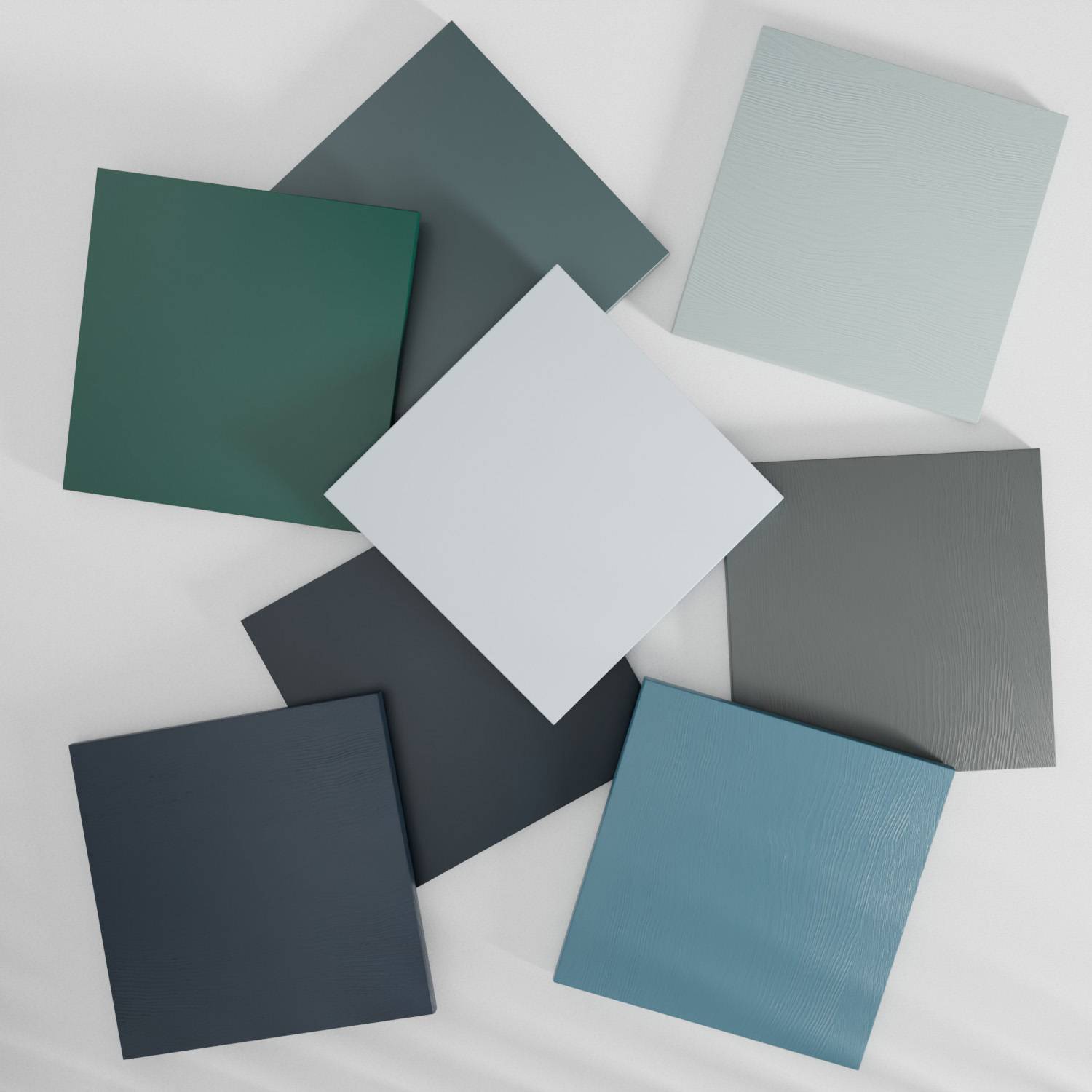 Eight square tiles in various shades of blue are arranged in an overlapping circular pattern on a light background. The tiles have a matte finish, with subtle textures visible on some surfaces.