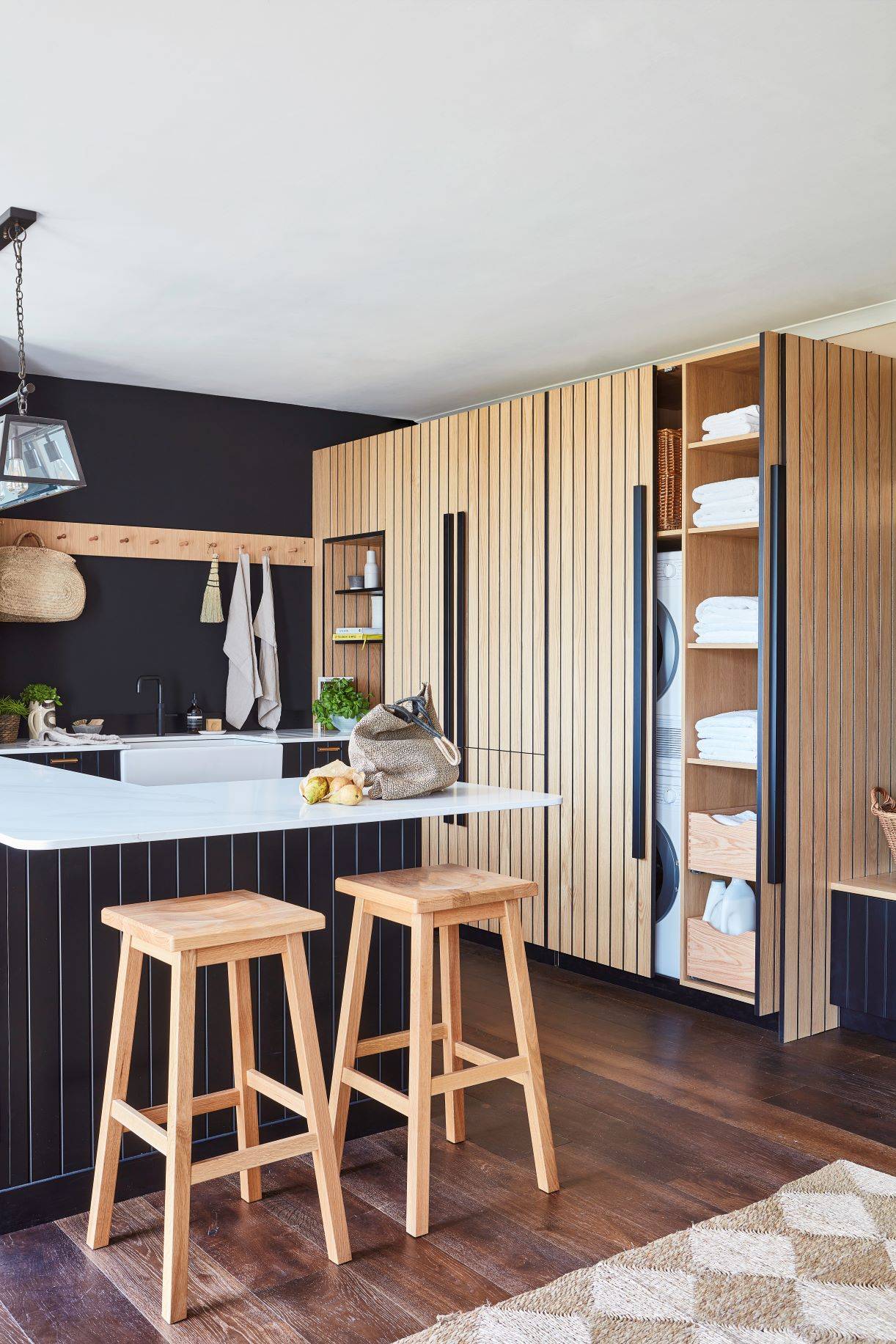 Ample storage solutions in the Kitchen, including stacked washing machine and dryer units neatly hidden behind pocket doors, maximising space utilisation.