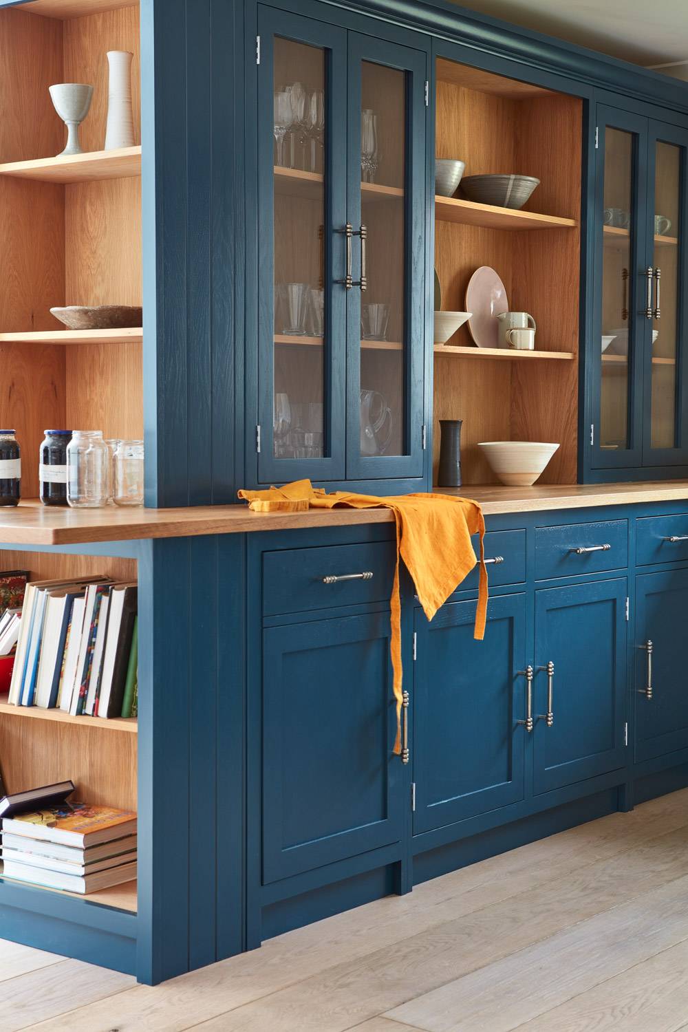 The Cley kitchen offers ample space for culinary adventures, with generous storage and a spacious layout. The use of blue base cabinets and grain-visible paint finish on the tall Shaker units showcases the natural beauty of the wood.