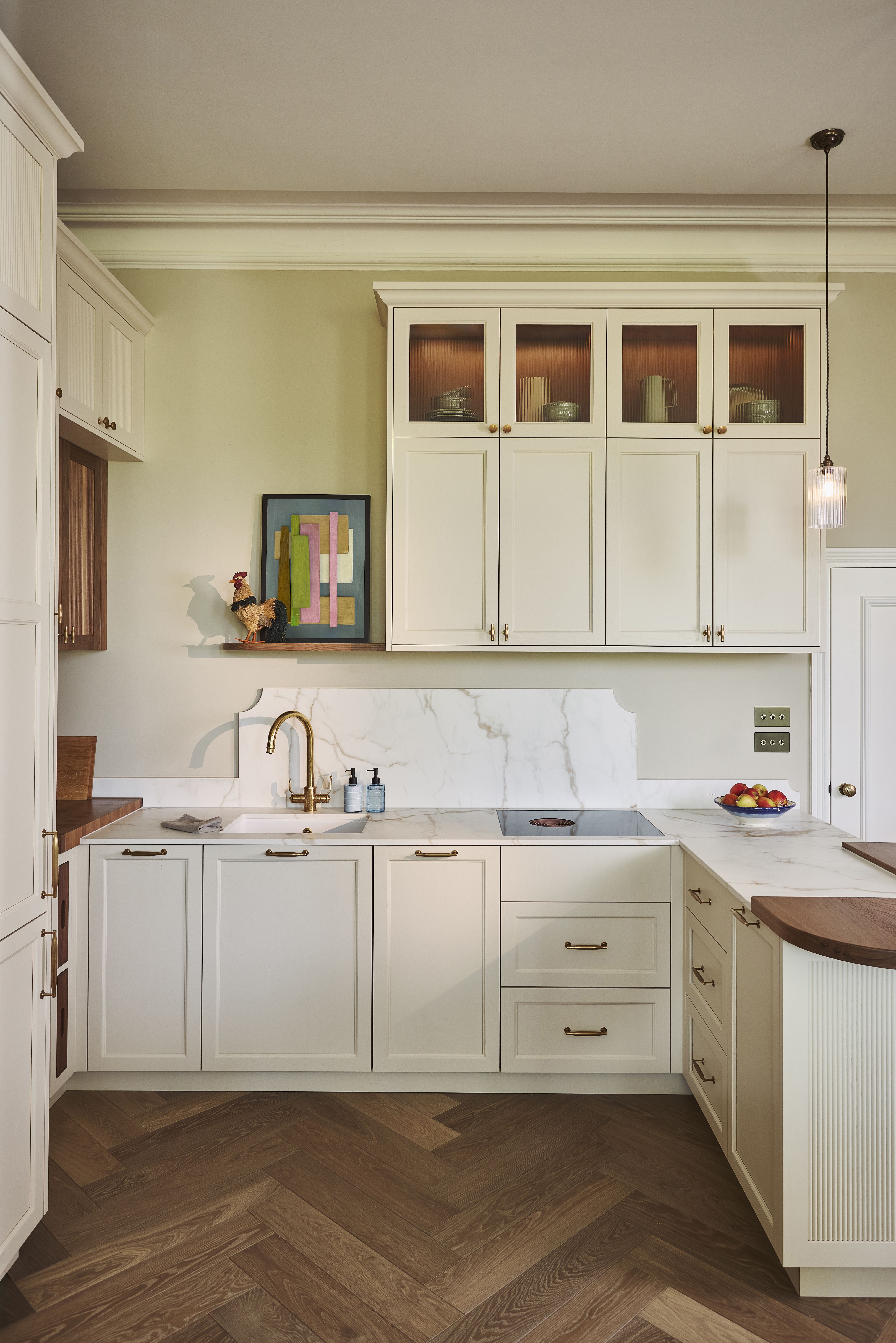 Old Chelsea kitchen by Naked Kitchens with cream painted cabinetry, reeded glass wall cabinets and a herringbone oak floor by Waxed Floors
