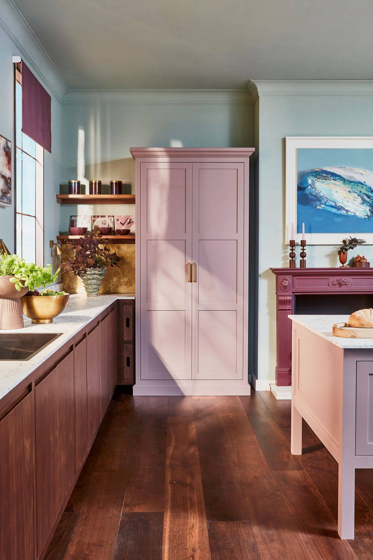 Become the centre of attention at this breathtaking drinks cabinet, where the harmony of walnut, rich purple hues, and aged brass creates an atmosphere of sophistication and elegance. The kitchen's ample space provides ample seating for enjoying drinks and conversation, while the integrated wine rack adds a touch of refined luxury.
